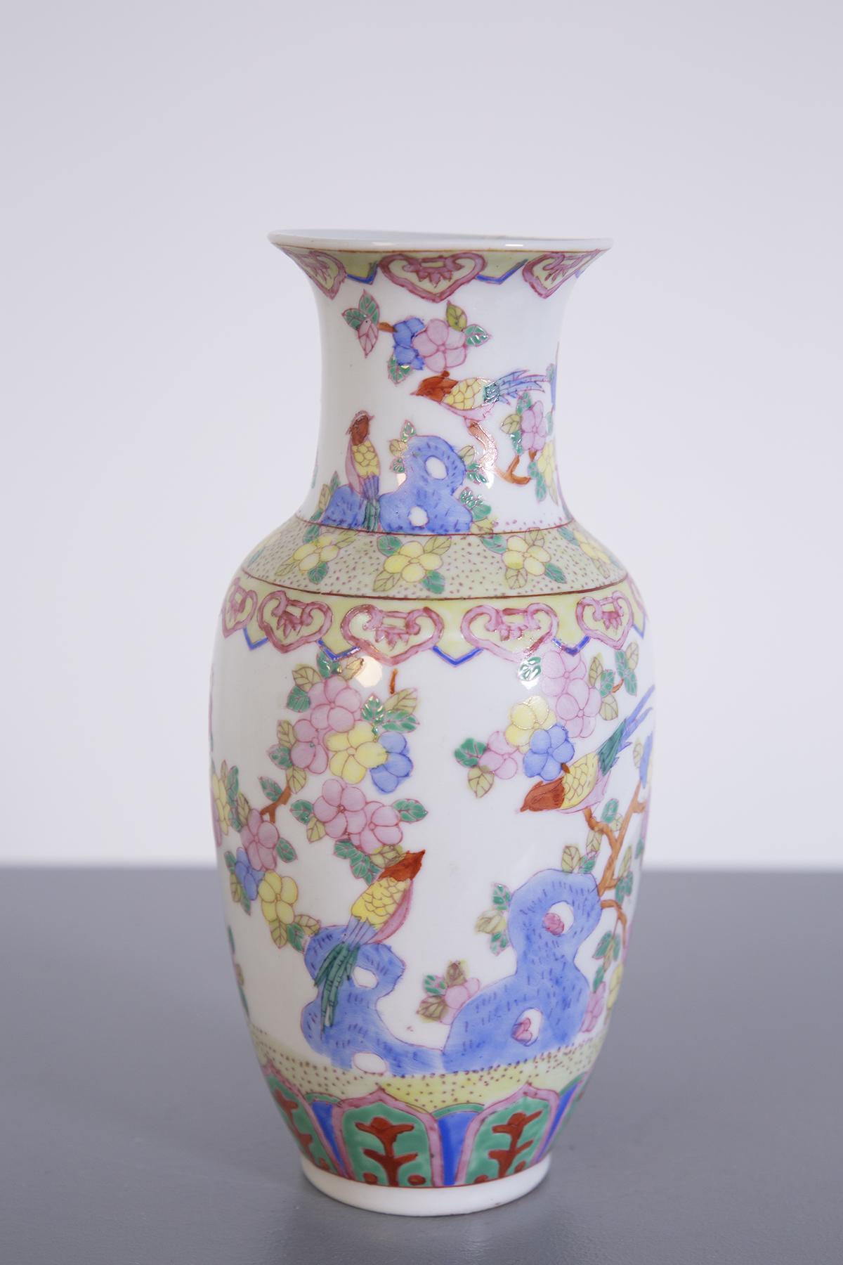 Vintage Chinese porcelain ornamental oriental vase dating from the early 1900s.
The vase is entirely hand painted, depicting flowers and birds.
The vintage Chinese porcelain vase has a sinuous shape, which sees a narrower base with a more domed