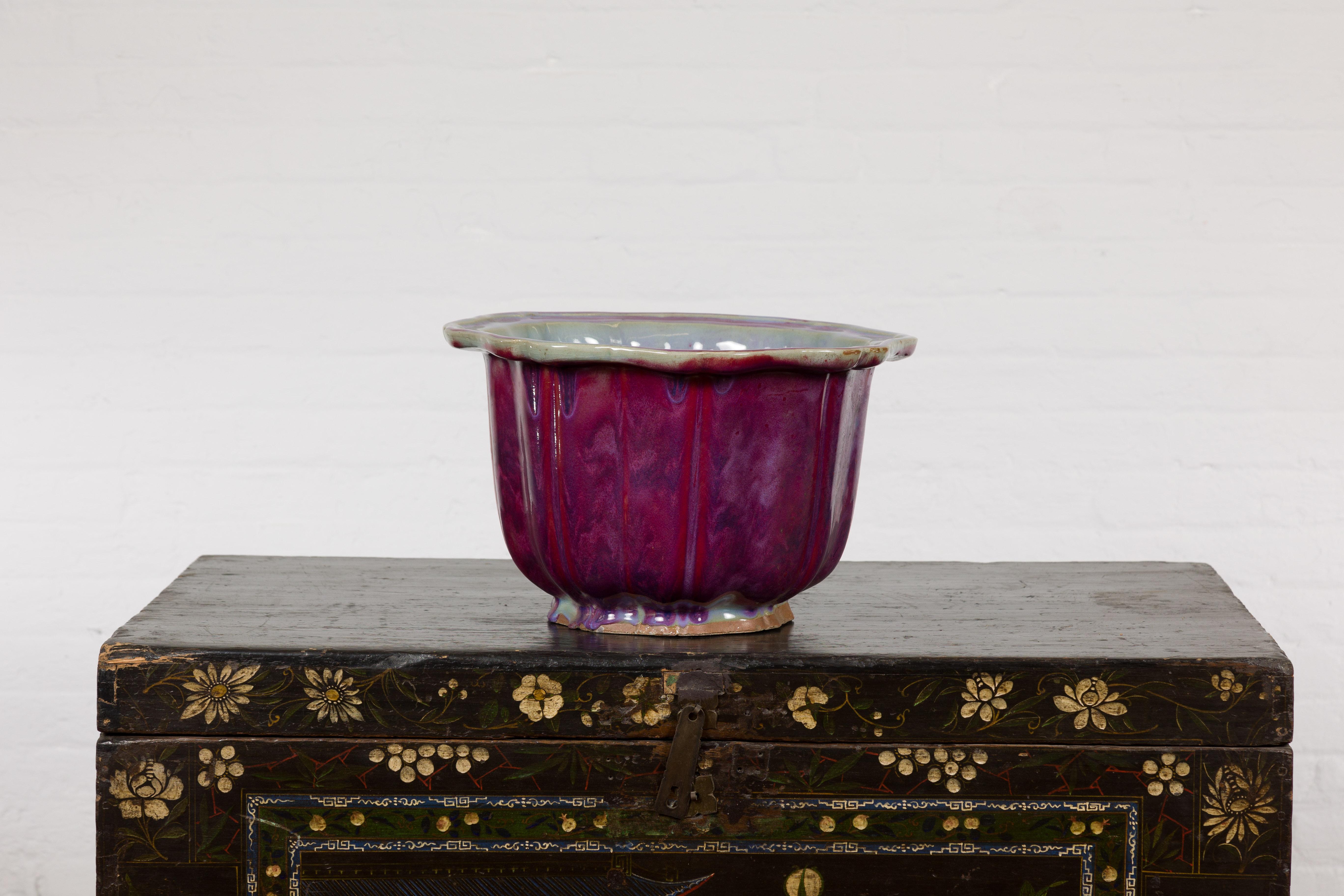 A vintage Chinese purple, blue marbleized red glaze flower pot with light blue inside, scalloped border at the top and calligraphy incised on the underside. Immerse yourself in the beauty of this vintage Chinese flower pot, adorned with a