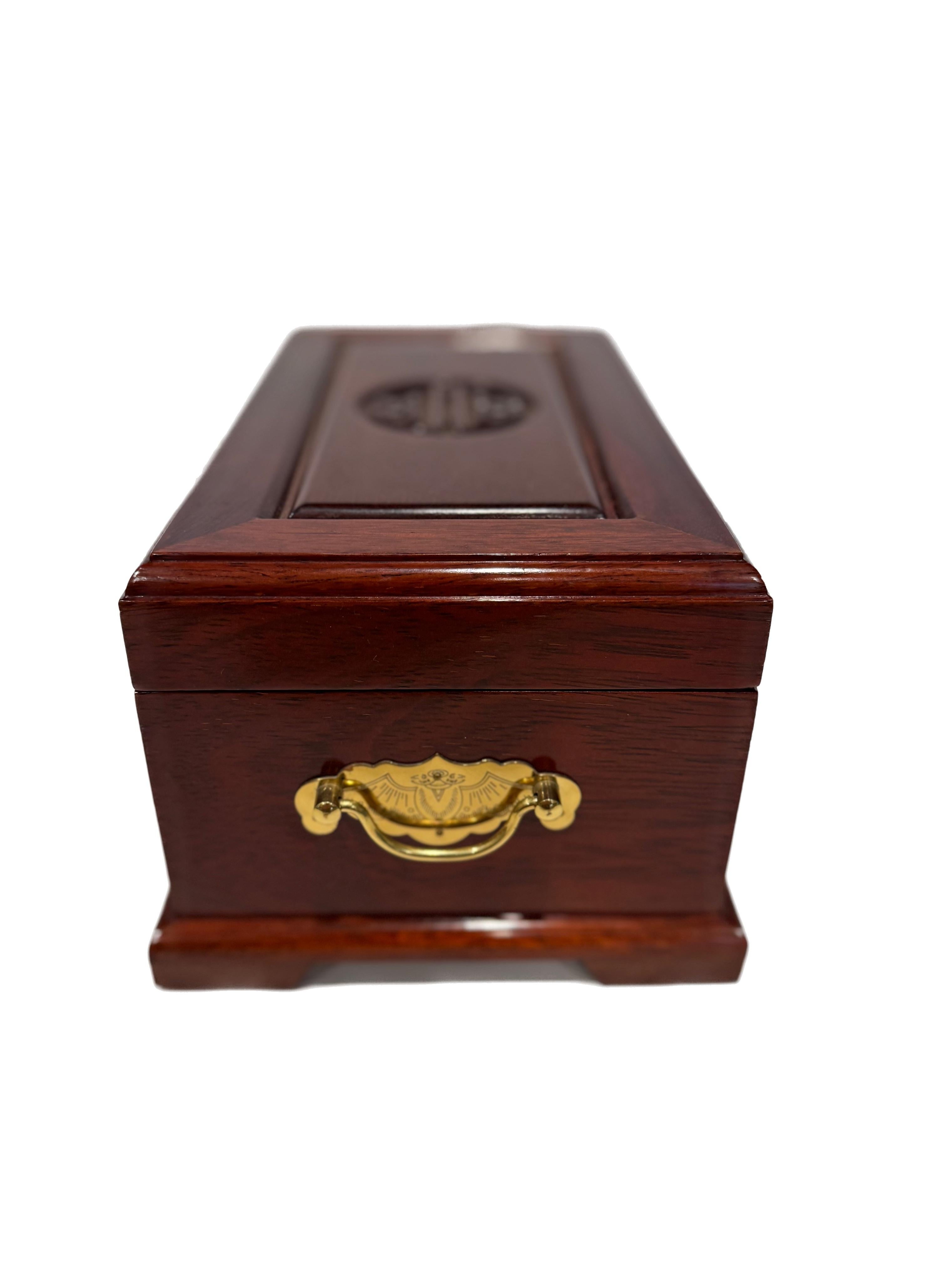 This vintage Chinese jewelry box is a beautiful addition to any collection.
Made from rosewood and gold plated brass, it exudes elegance and sophistication. The intricate design on the box adds a touch of traditional Chinese artistry, as the symbol