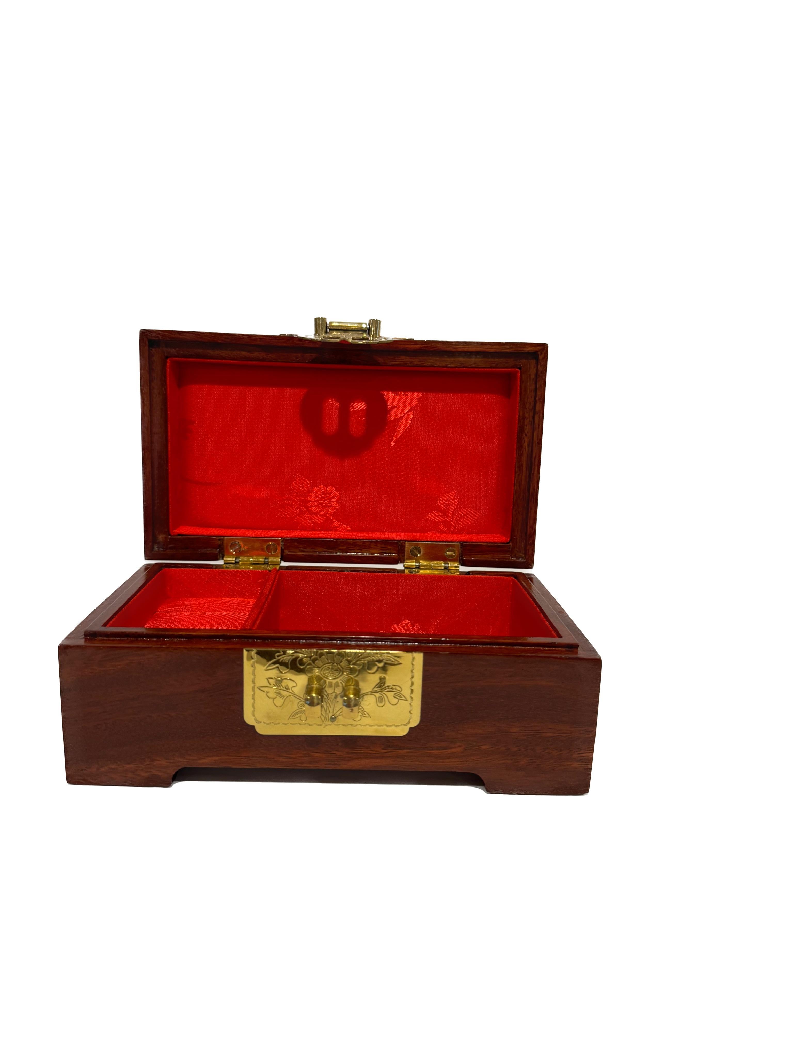 This vintage Chinese jewelry box is a beautiful addition to any collection, now in size small. 
Made from rosewood and brass, it exudes elegance and sophistication. The intricate design on the box adds a touch of traditional Chinese artistry, as the