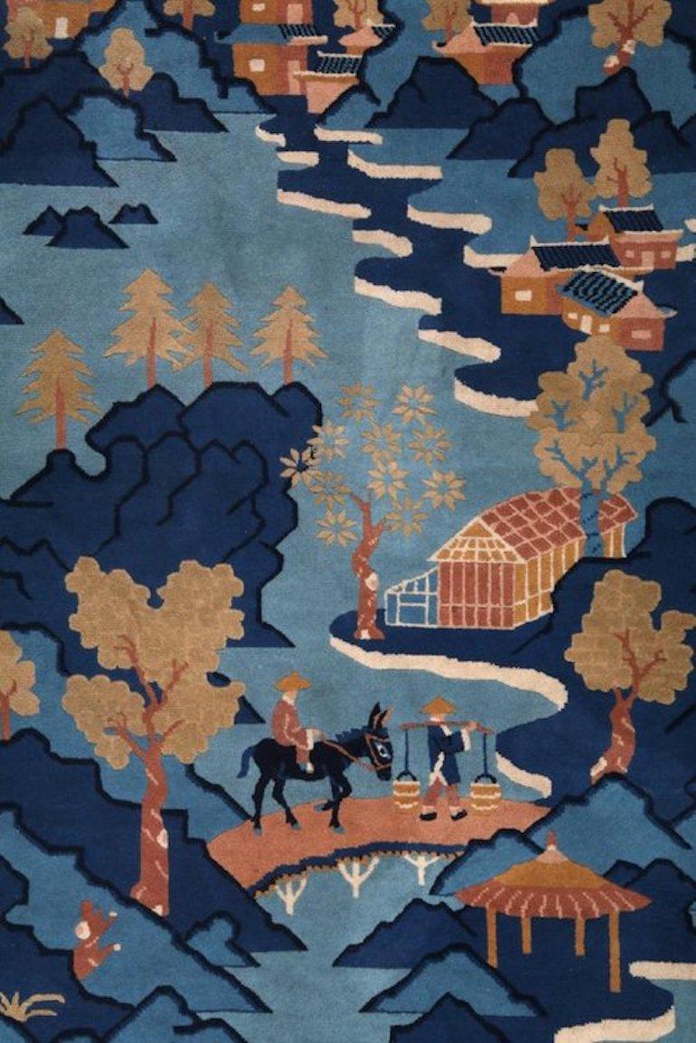 Ce tapis décoratif chinois vintage, fabriqué à partir de 100 % de laine, présente un captivant motif de village de pêcheurs, avec des tons bleus sereins accentués par des arbres complexes. Le design allie l'art traditionnel chinois aux motifs