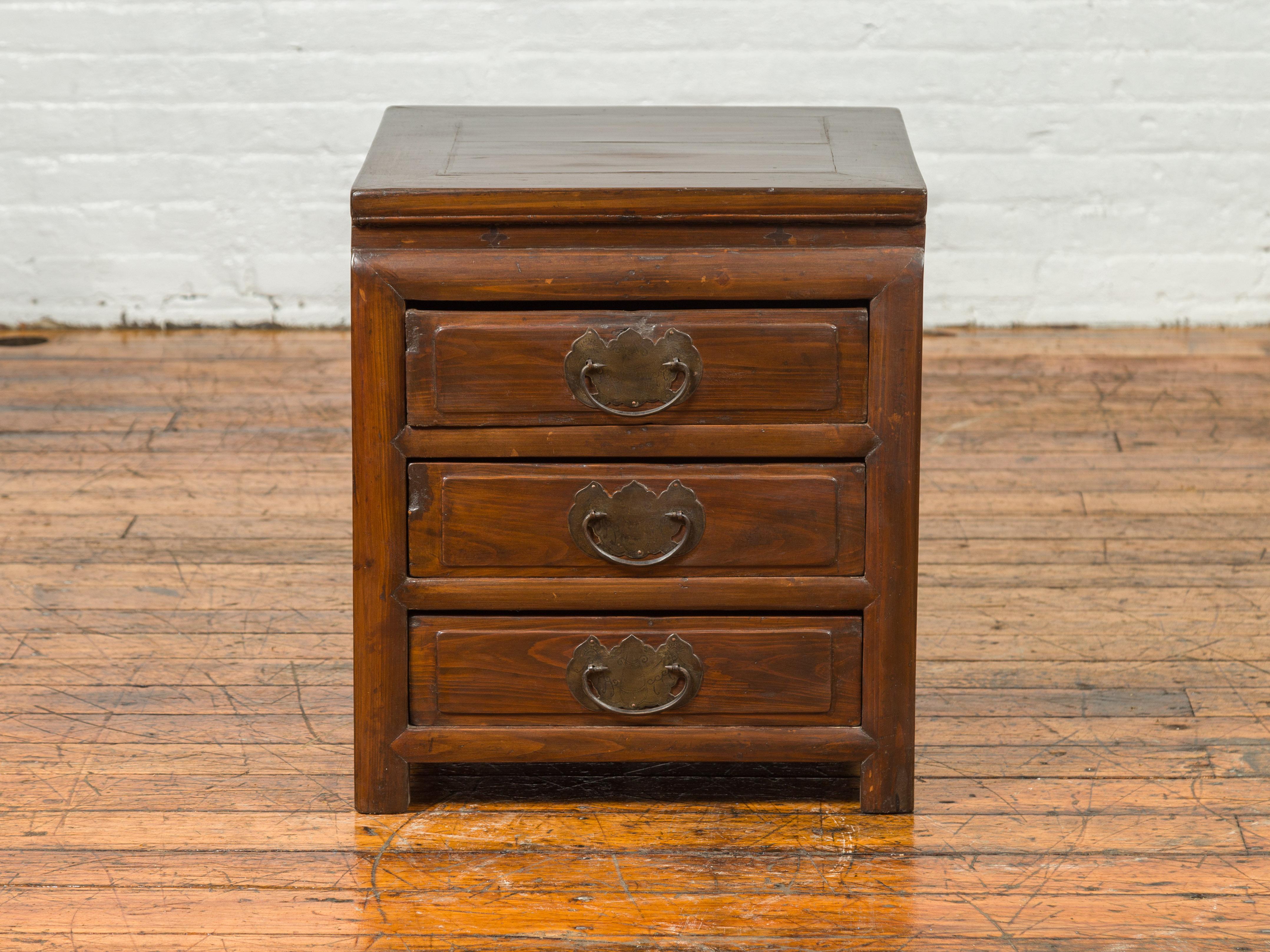 A vintage side chest from the mid-20th century, with three drawers and traditional hardware. This mid-20th century Chinese side chest merges traditional aesthetics with functional design, making it a timeless addition to any modern home. Featuring a