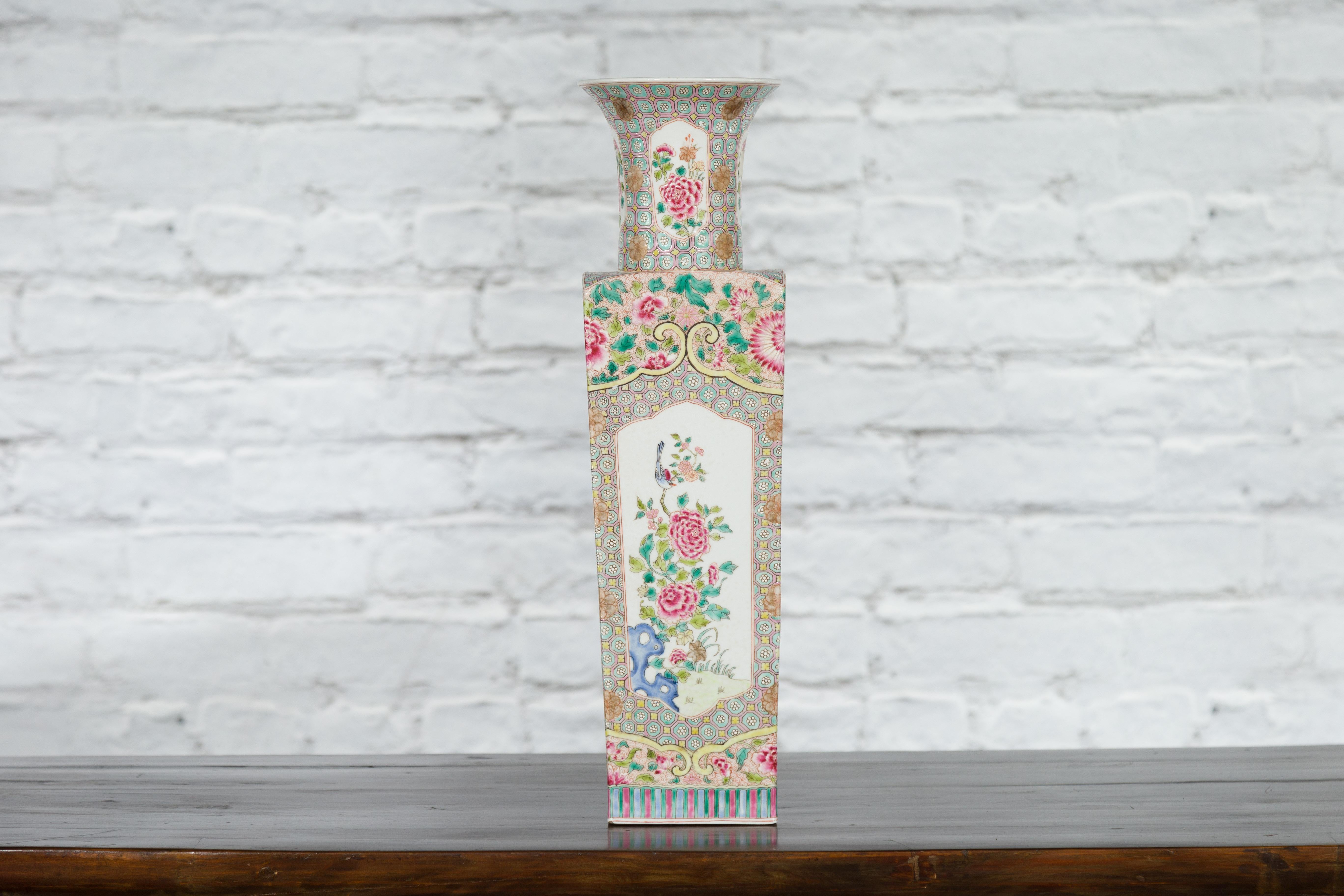 A vintage Chinese square-shaped vase from the mid 20th century with floral décor. Created in China during the Midcentury period, this vase features a flaring neck showcasing a 4