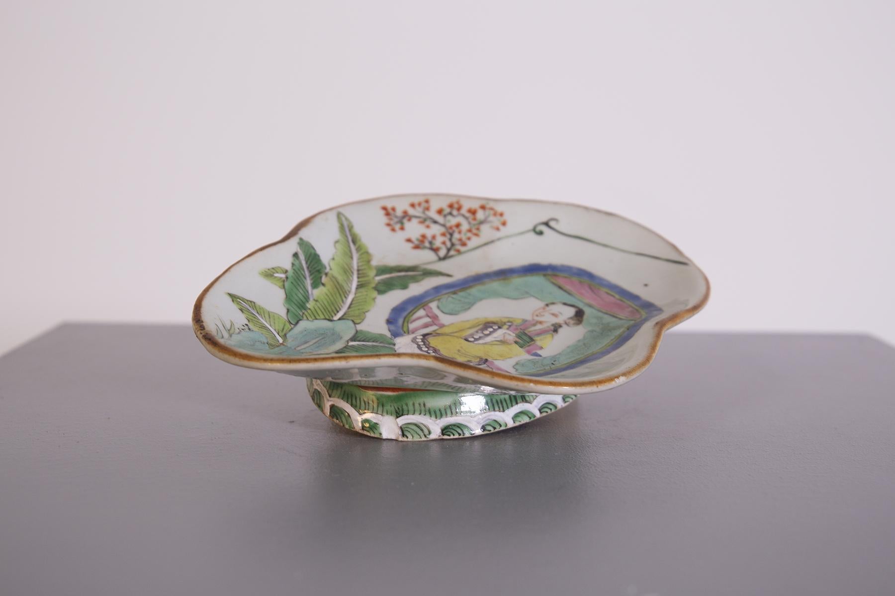 Beautiful vintage Chinese ceramic tray dating from the early 1900s, also useful as a pocket emptier or centerpiece.
The vintage Chinese tray is entirely hand-painted and depicts a woman kneeling happily looking at flourishing nature. Also painted