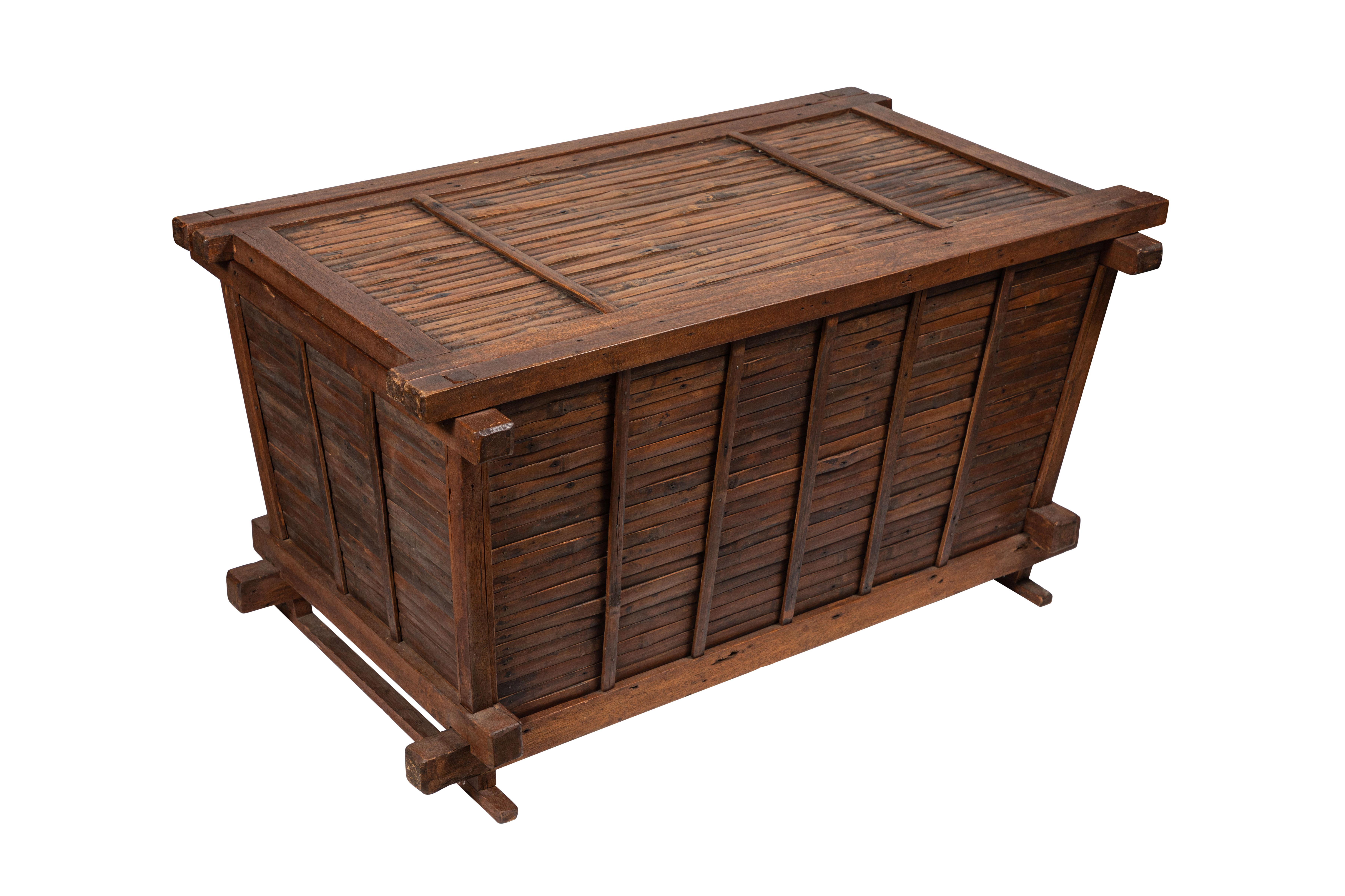 This rectangular vintage Chinese trunk made of split bamboo sides and a wooden frame has a loose sliding top and sits on stretchers at base. The frame features mortise and tenon joins; elsewhere, old nails. Note that this unusual and functional