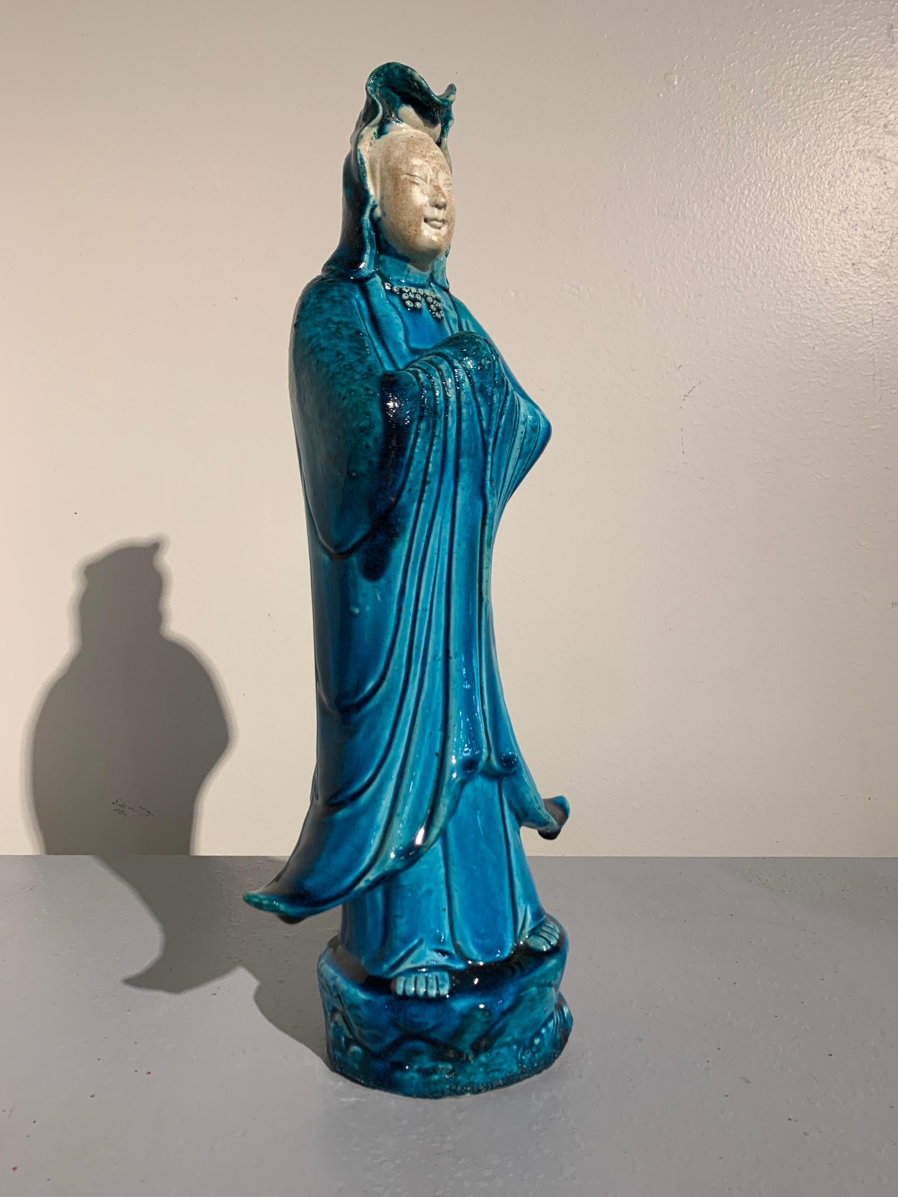 A vintage tall, turquoise glazed porcelain figure of Guanyin, the Goddess of Compassion and Mercy, with a 