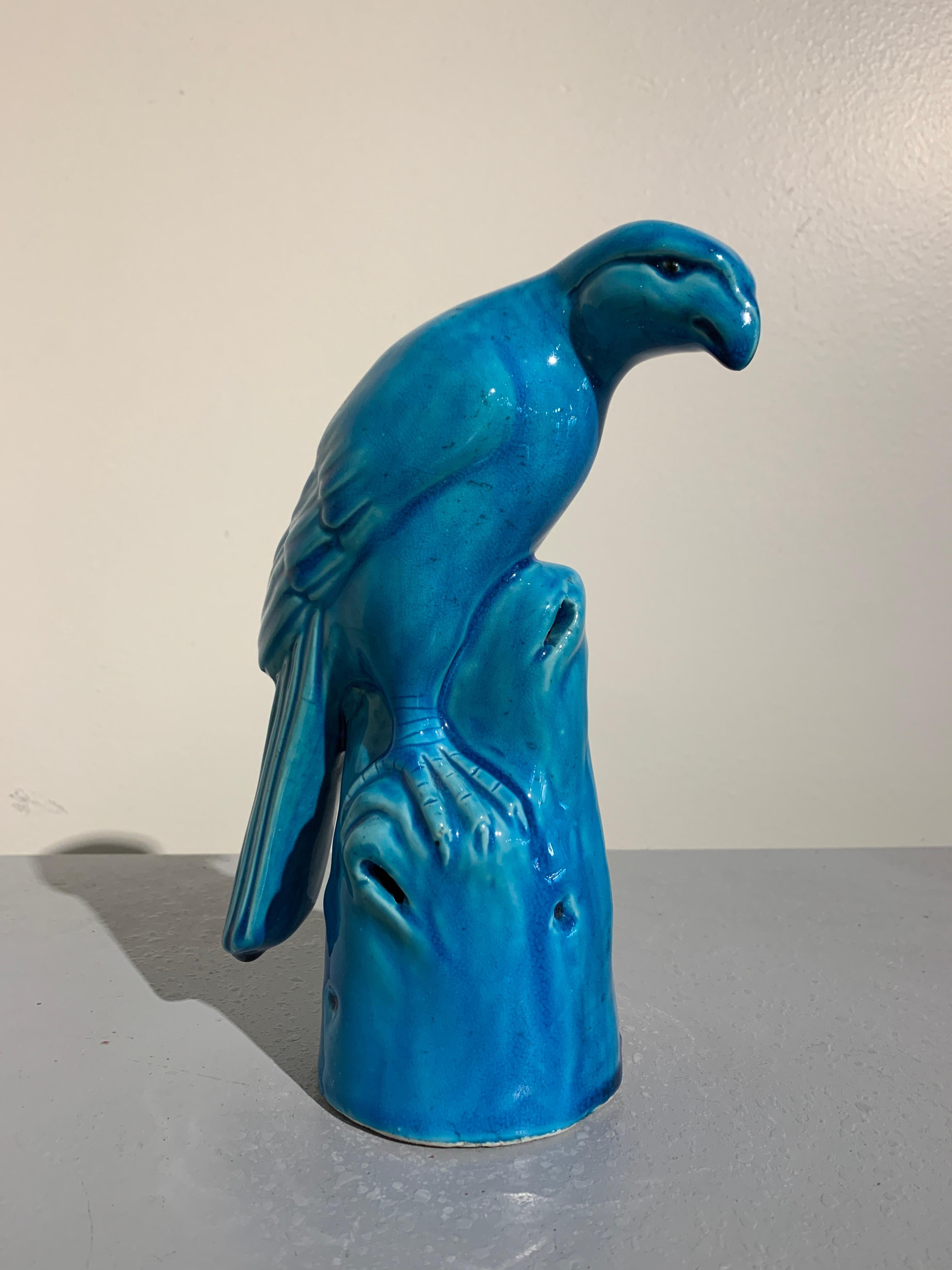 A charming vintage Chinese export turquoise glazed porcelain model of a hawk, mid-20th century, China.

The long tailed hawk portrayed perched on a rocky outcrop, somewhat hunched over, head down, gazing intently at some unseen object. The hawk's