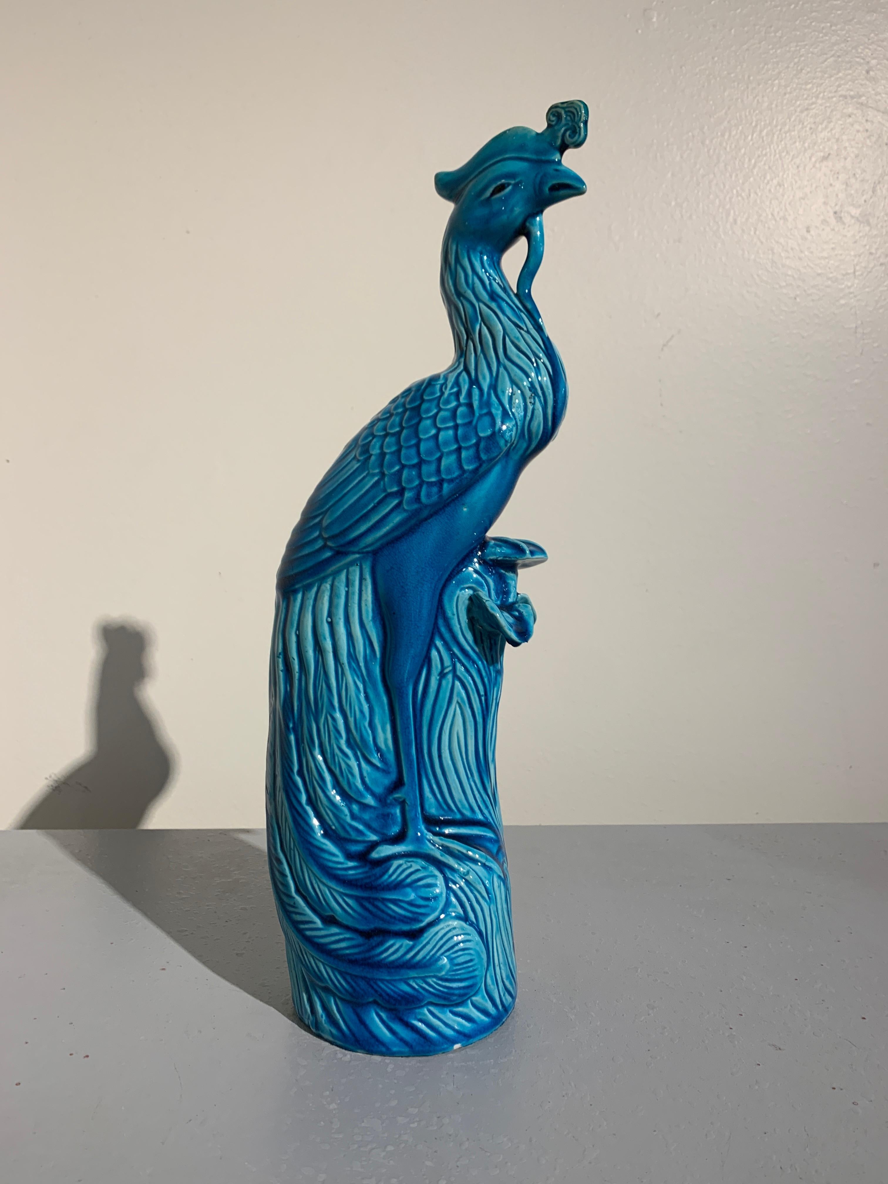 A stylish vintage Chinese Hollywood Regency turquoise glazed porcelain phoenix, mid-20th century, China.

The phoenix, called a fenghua in Chinese, is portrayed perched on a rocky outcrop, large wings folded against its body, its tail sweeping out
