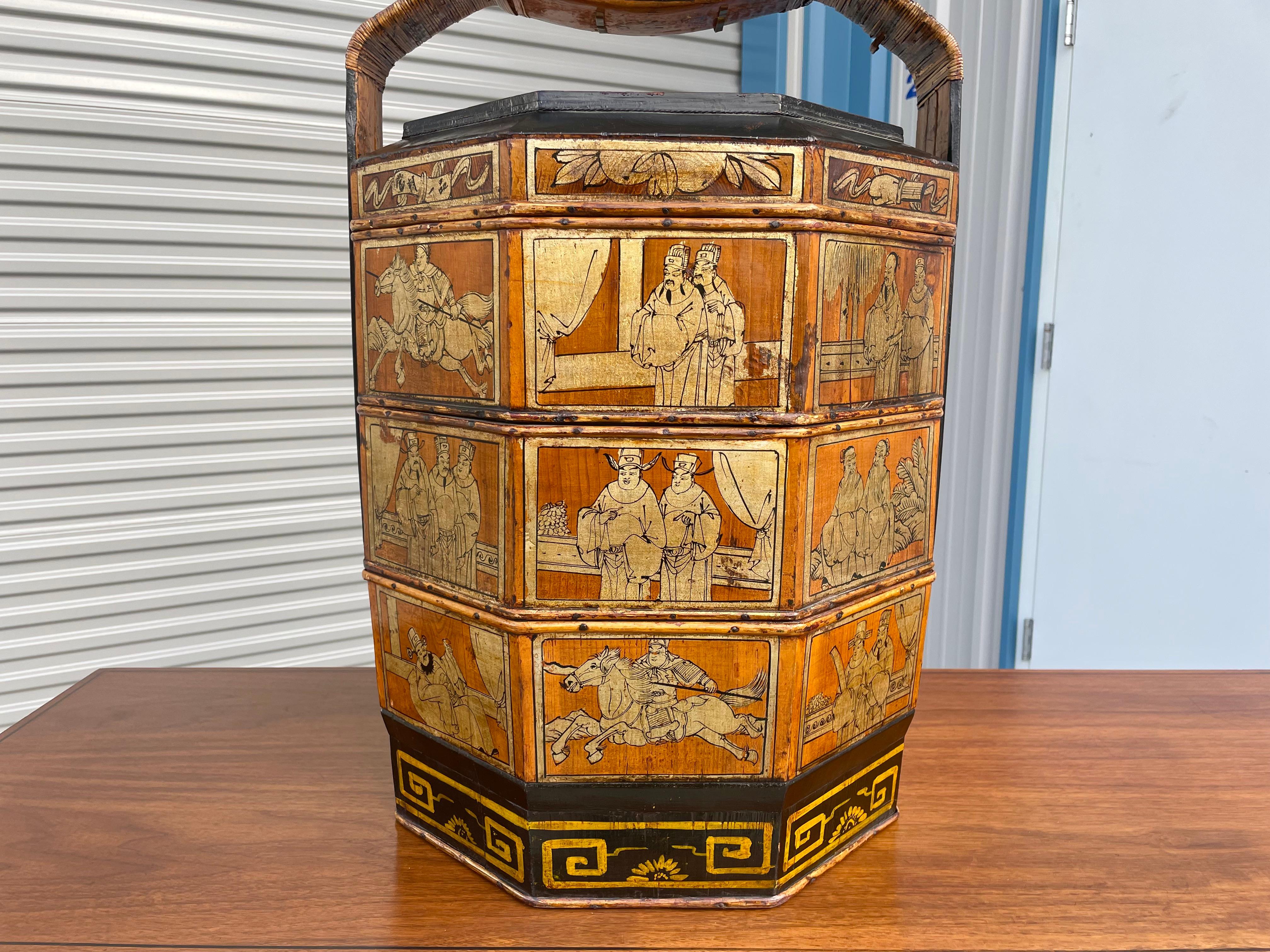 Vintage Chinese wedding basket designed and manufactured in Asia circa 1900s. This beautiful Chinese wedding basket features a painted decor that tells us a story. The basket also comes with three stackable trays. A perfect addition to your home or