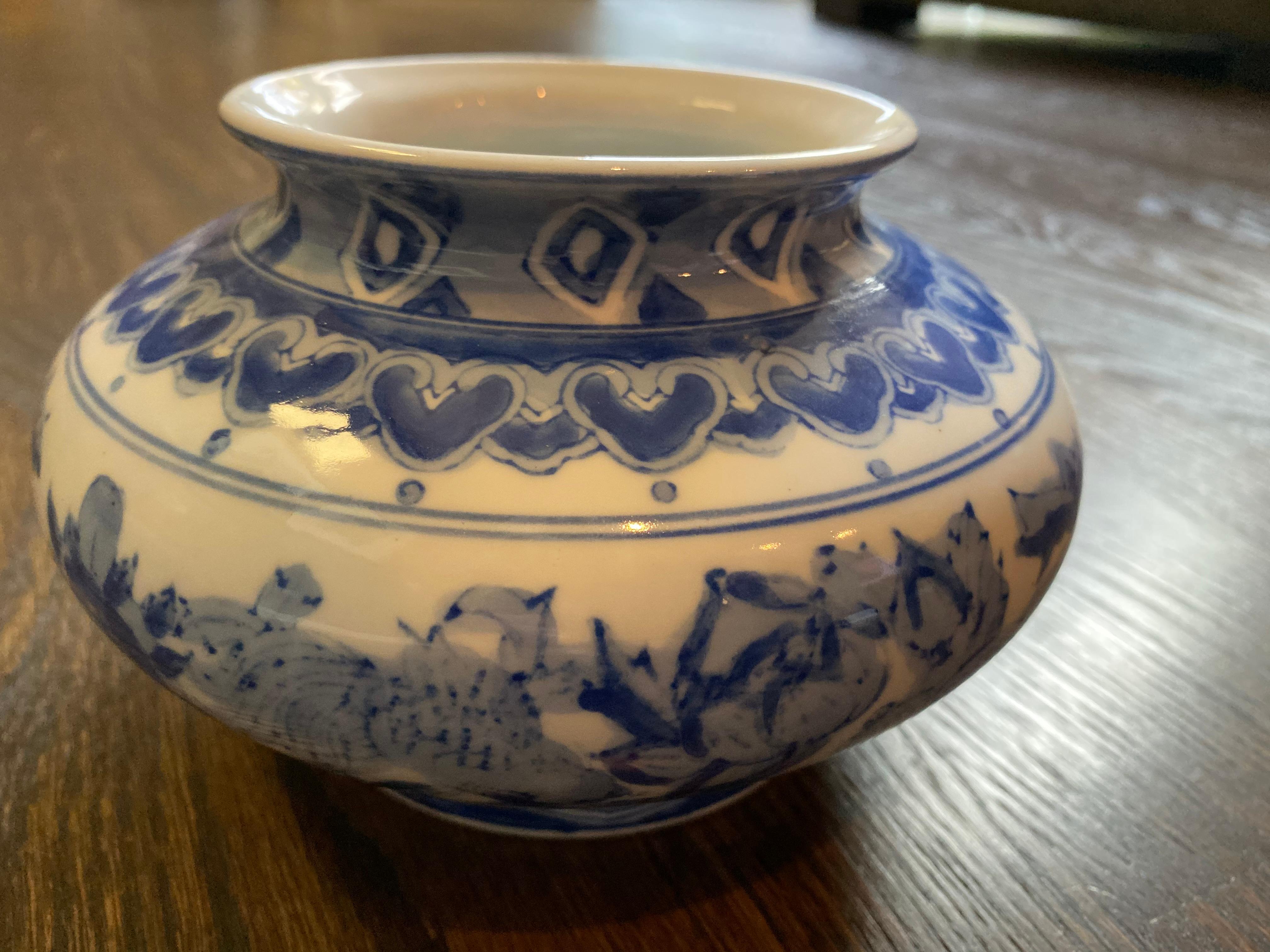 Vintage chinoiserie blue and white vase 

This is a Chinese decorative porcelain vase pot in blue and white color finish. The theme is oriental scenery graphic. It has a round fat body shape with a large mouth opening for flexibility.