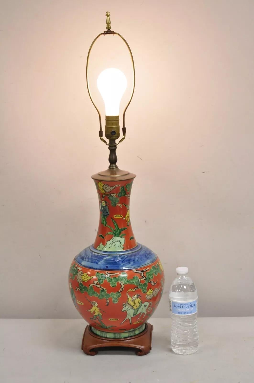Lampada da tavolo a vaso bulboso in porcellana di Chinoiserie d'epoca con scene dipinte a mano su base di legno in arancione e blu. Circa metà del XX secolo. Misure: 31