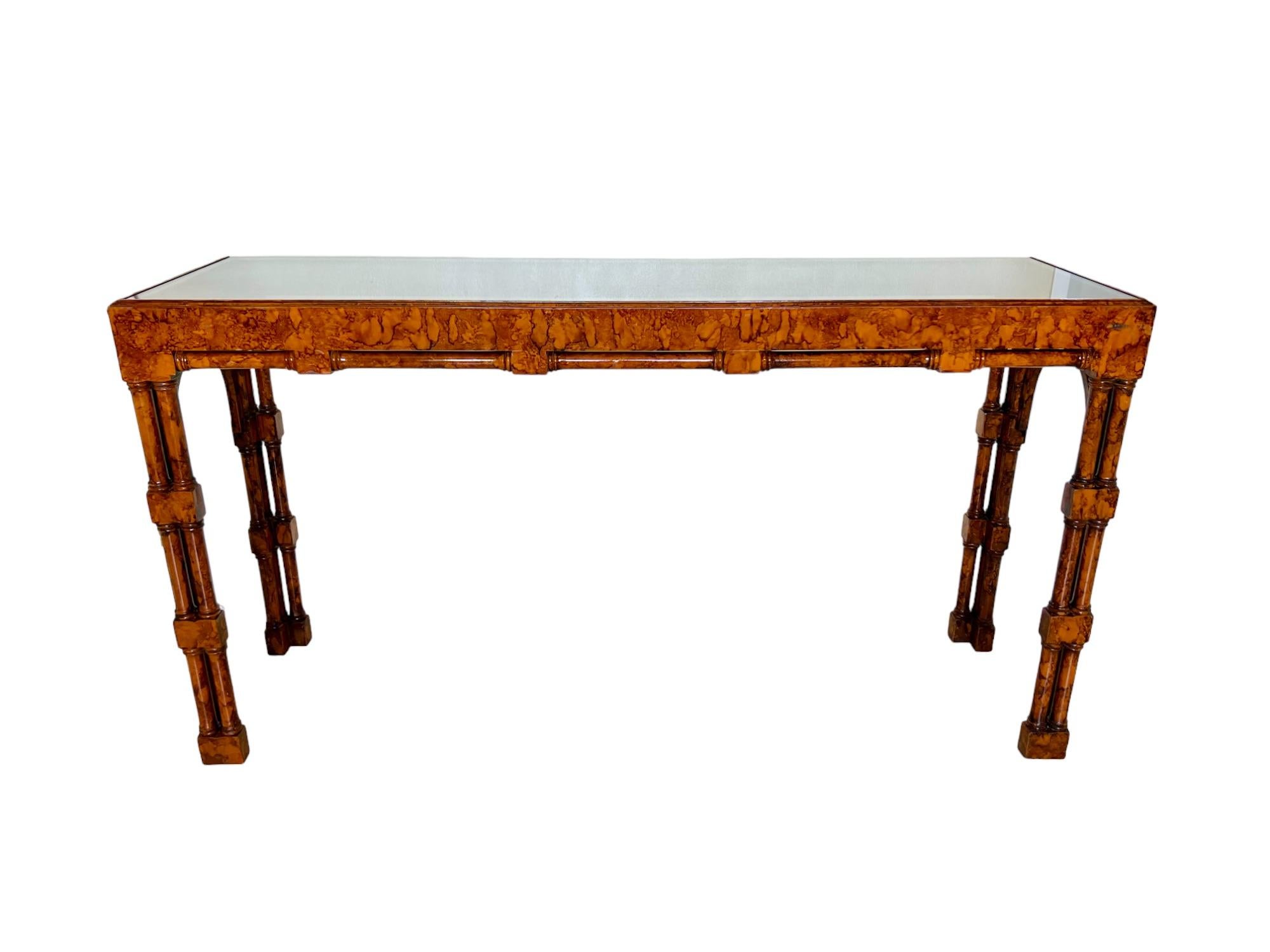 A gorgeous vintage chinoiserie style rectangular console table with an inset glass top. It features a wood frame with carved and turned details, triple shaft legs and a beautifully toned faux burl wood laminate finish. 

Dimensions: 55.5