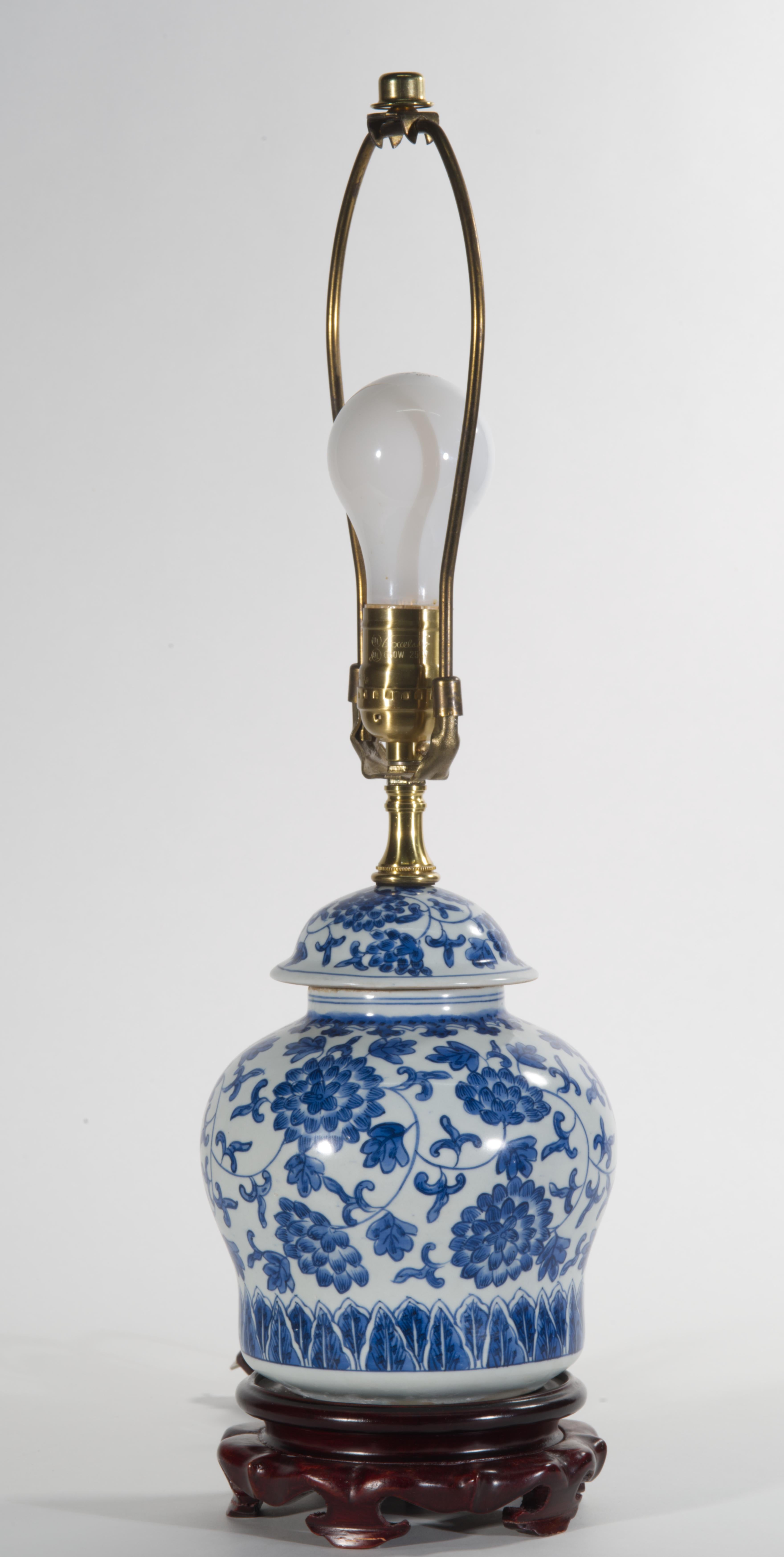 Charming small vintage table or accent lamp features abstract hand painted decor with ornate garlands of large flowers and leaves, depicted in traditional style in various shades of cobalt blue on white background.

The ceramic body in rounded