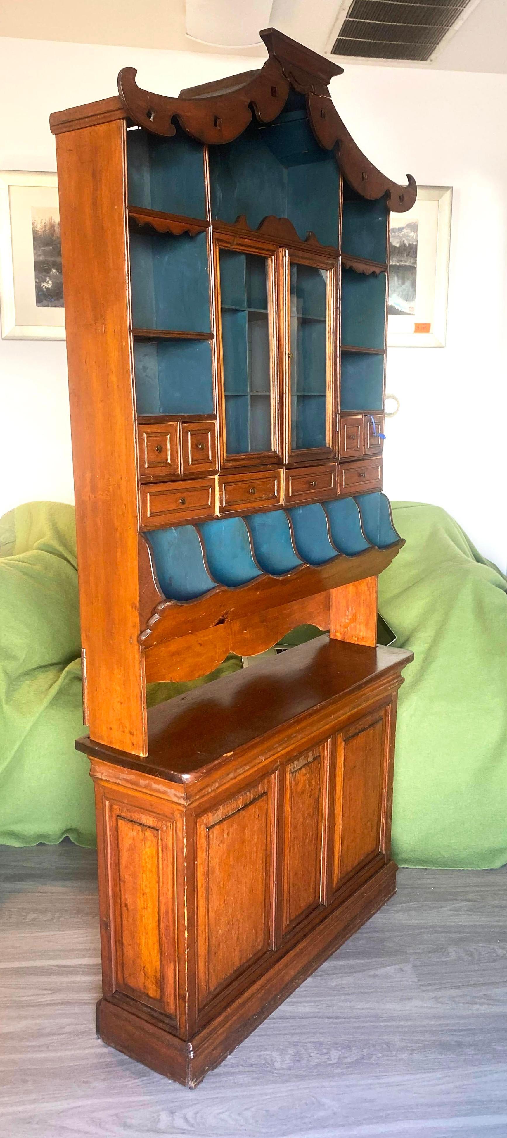 Vintage Chinese Chippendale display cabinet hutch with blue painted interior shelves. The detailing on this large cabinet is primitive yet classically elegant and tasteful incorporating the best traditional designs elements from both the East and
