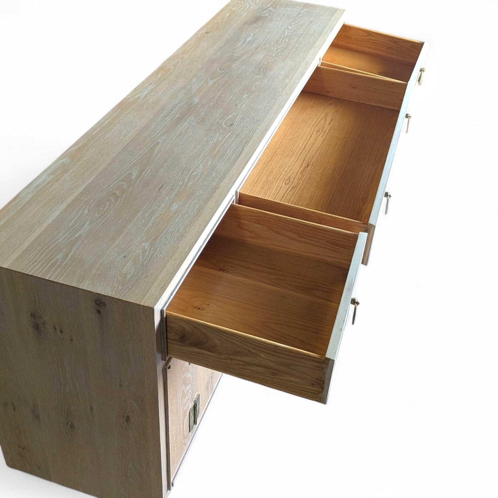 Eine elegante Chinoiserie-Credenza, ein Sideboard oder ein Buffet aus gebleichtem Holz mit markanten Messingbeschlägen.

Von der Chinoiserie inspiriertes Design mit einer klaren, modernen Ästhetik durch das nachbearbeitete Holz.

Dieses Möbelstück