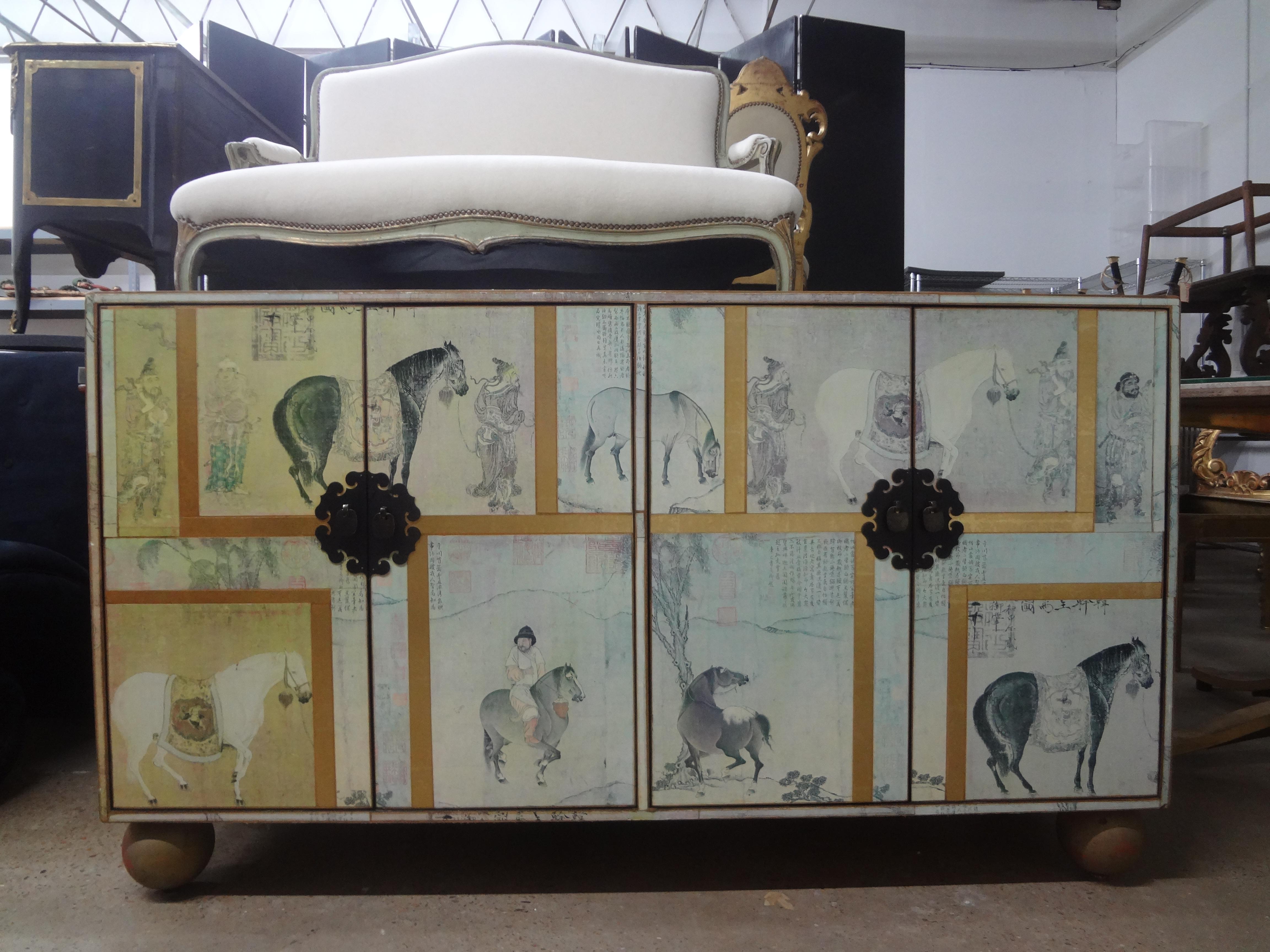 Vintage Chinoiserie Decopage Credenza.
Stunning 20th century four door credenza, buffet, chest or console with a beautiful equestrian themed Chinoiserie grisaille decopage design resting on giltwood sphere feet.
This lovely credenza has interior