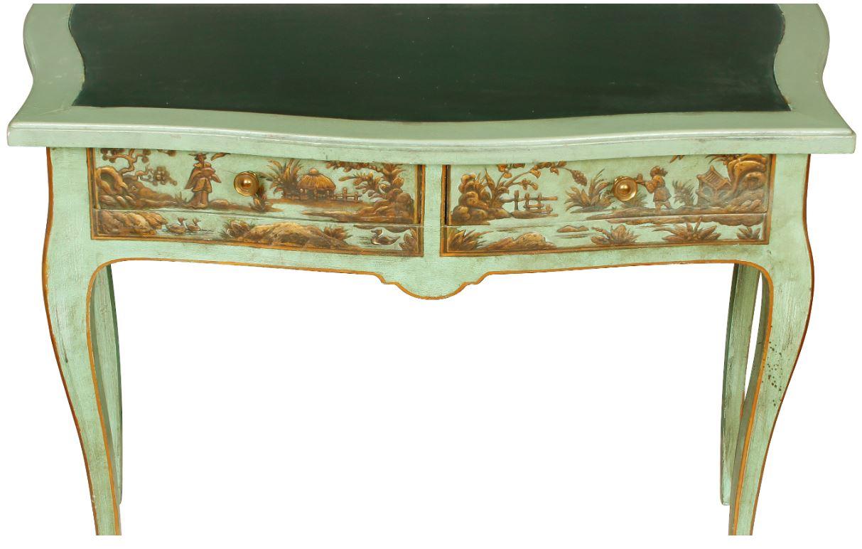 Vintage decorated writing table in green painted finish with curved front and legs and chinoiserie details painted in gold.