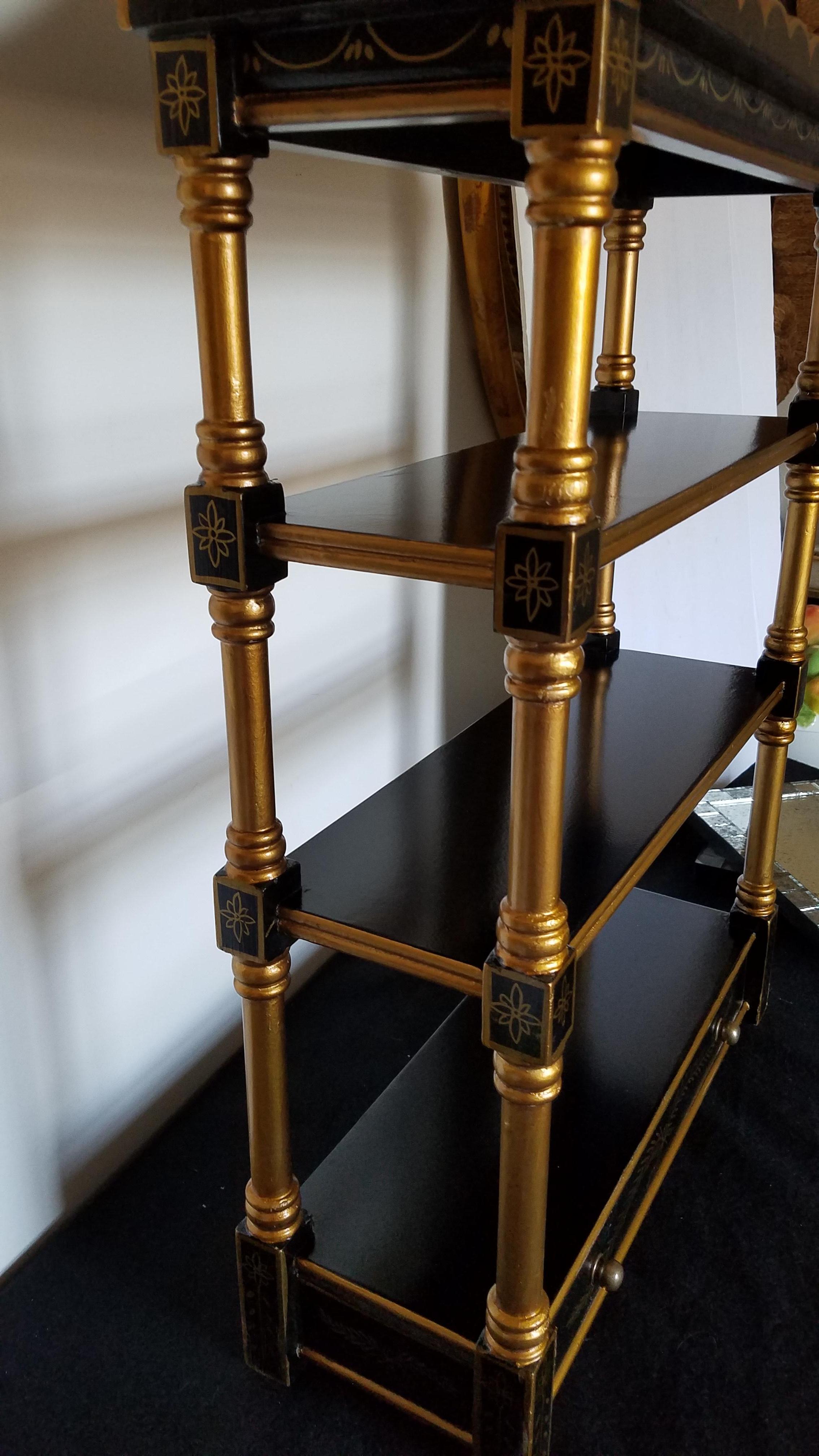 Elegante estantería de pared o sobremesa con 4 baldas y un cajón. El fondo ebonizado con la parte superior dorada y toda la decoración es una forma preciosa de exponer una pequeña colección.