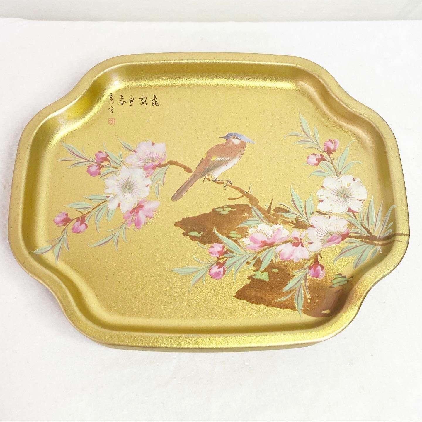 Amazing vintage Elite gold metal tray creates a layer of “art” and interest wherever it is placed. Small in scale but brimming with style, this tray delivers vibrant color in rich metallic gold, accented by beautiful greens, pinks. blue and white.