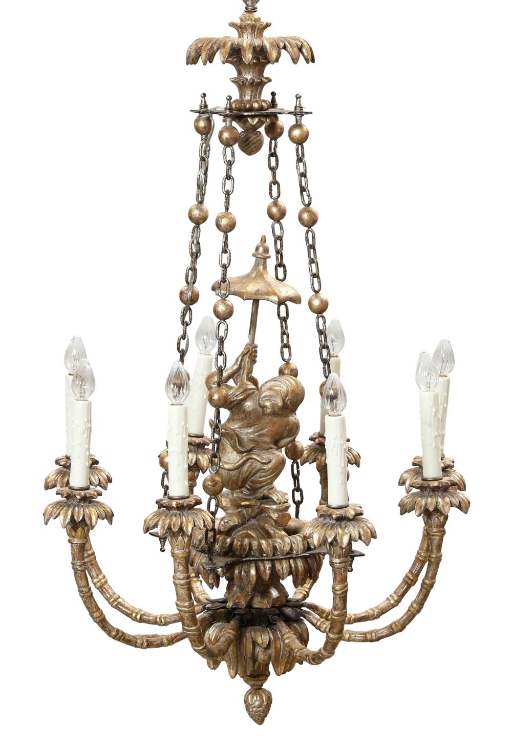 Vintage mid-century chandelier in the Chinoiserie style crafted from hand-carved giltwood featuring a Monkey  figure with umbrella and eight electrified candle arms with faux wax candle covers.  Ready for use.