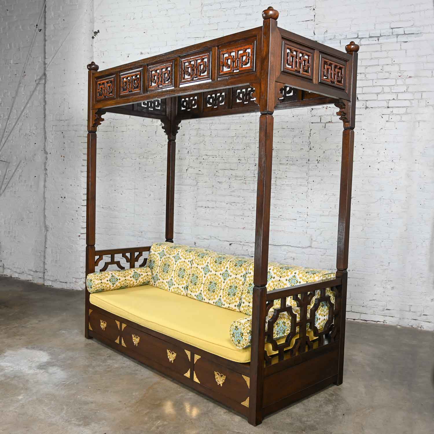 Magnificent vintage Chinoiserie hand carved canopy daybed in the style of a Chinese wedding bed, comprised of Rosewood colored stained wood, soft foam seat cushion, 3 loose back bolster cushions, 2 round arm bolster cushions, all with zippers, and