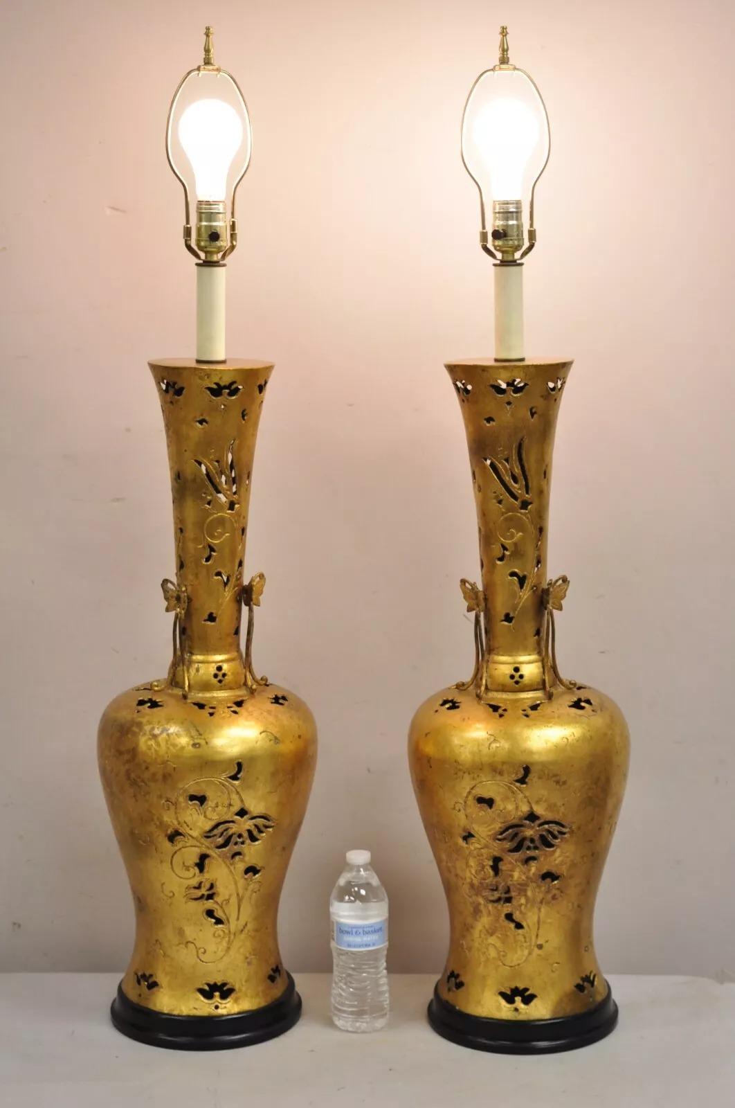 Paire de grandes lampes de table en métal doré, style Chinoiserie James Mont. L'objet se caractérise par un haut corps en métal décoré et percé, des accents de papillon appliqués, une base en métal ébonisé, un style et une forme remarquables. Circa