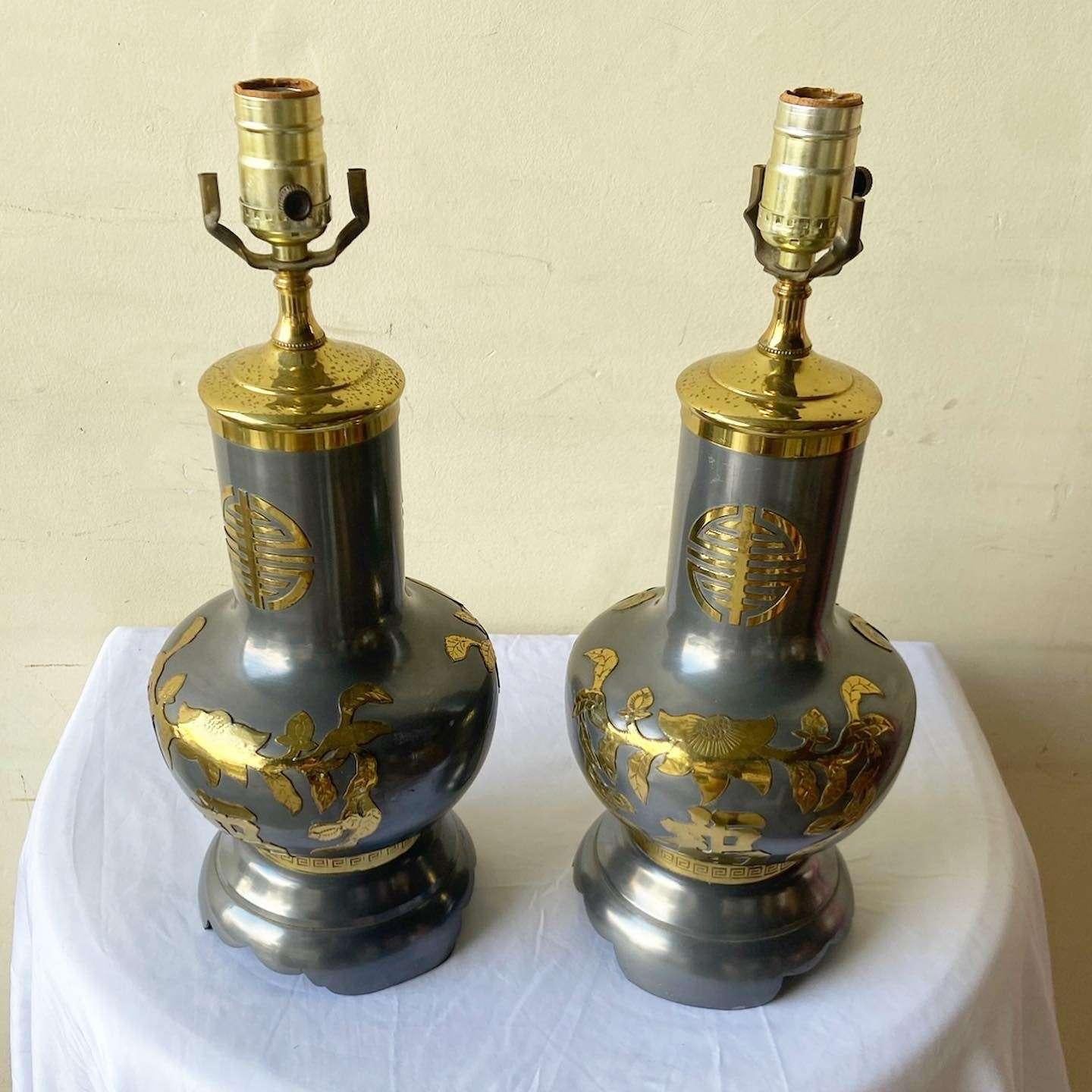 Exceptional pair of vintage chinoiserie metal table lamps. Each feature a metal body with gold plating of Chinese designs and letters.
