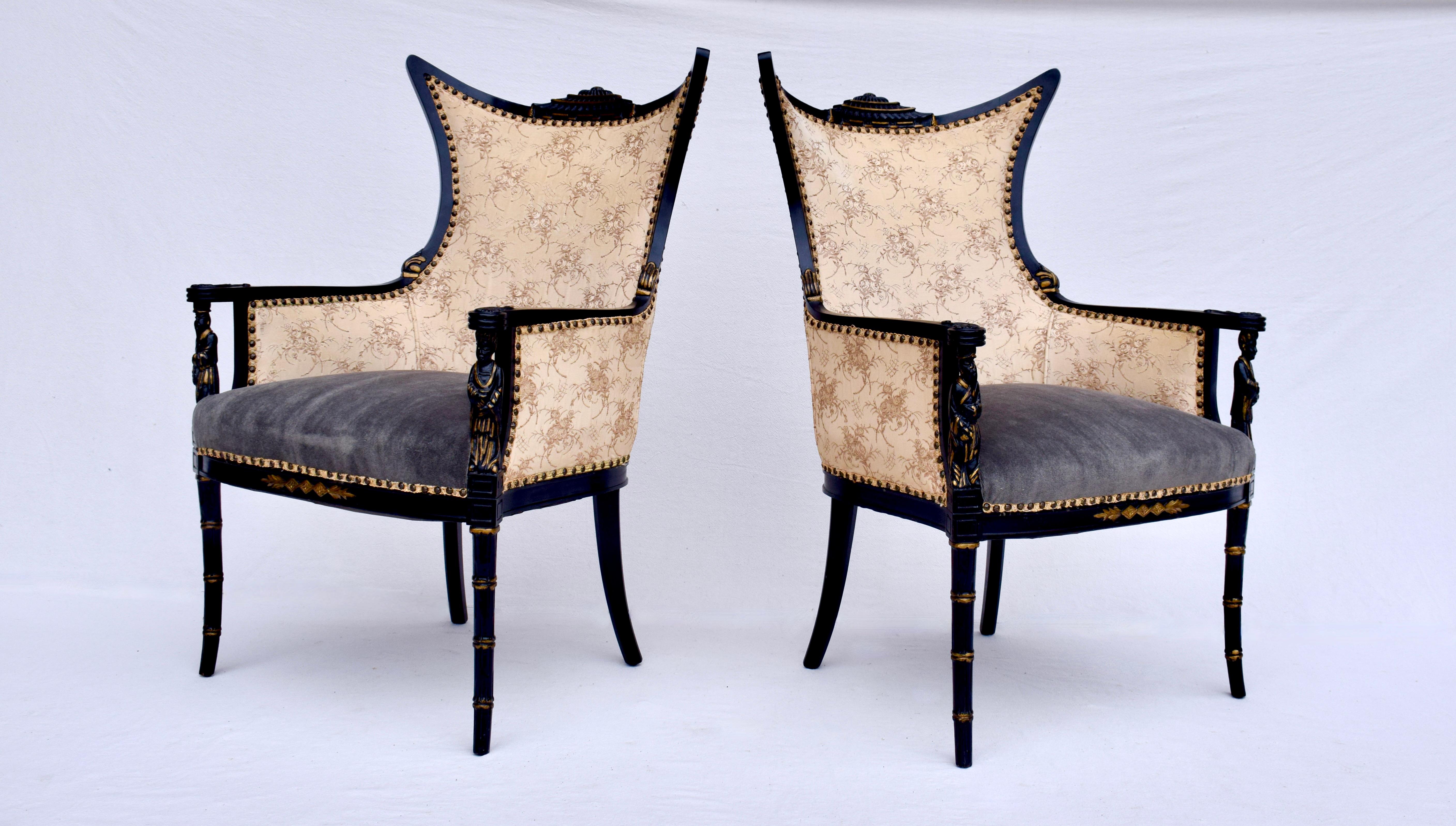 A striking pair of Hollywood Regency Chinoiserie armchairs with all original ebonized wood frames, carved figural arm rests, pagoda shaped crests on slightly splayed faux bamboo legs. Original Brocade upholstery is in beautifully maintained