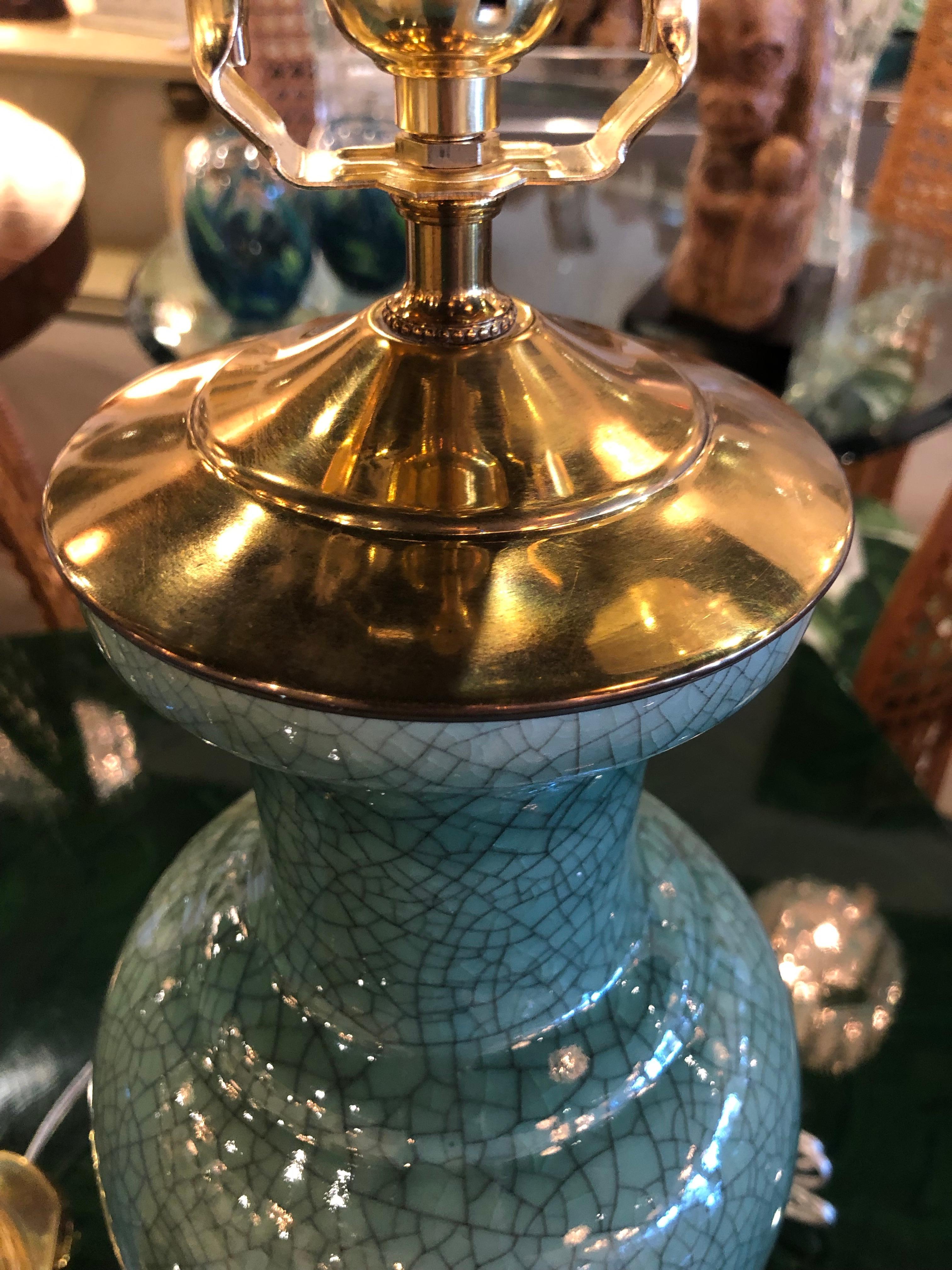 Lovely pair of vintage green crackle finish table lamps with brass pagoda tops. Newly wired with all new brass hardware. Original brass finials. No chips or breaks.
Base is 6 x 6
Lamps is 21.5 H to finial and 28 to finial.
 