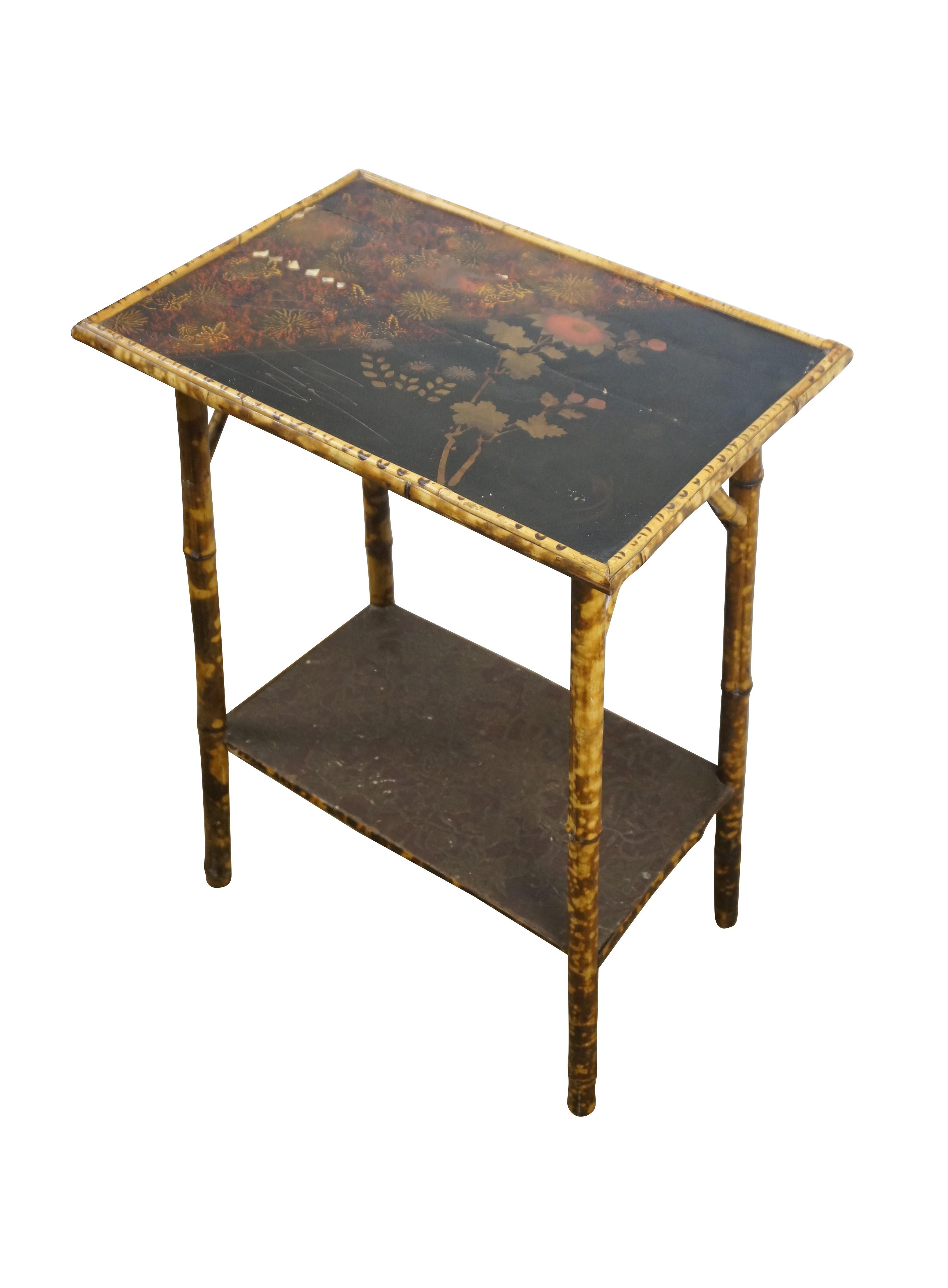 Tavolo occasionale e d'accento in bambù bruciato della metà o dell'inizio del XX secolo con piano laccato. Realizzato in bambù con motivo a tartaruga e piano in lacca nera inciso con un disegno a cineserie semi-astratto di un colibrì che vola tra il
