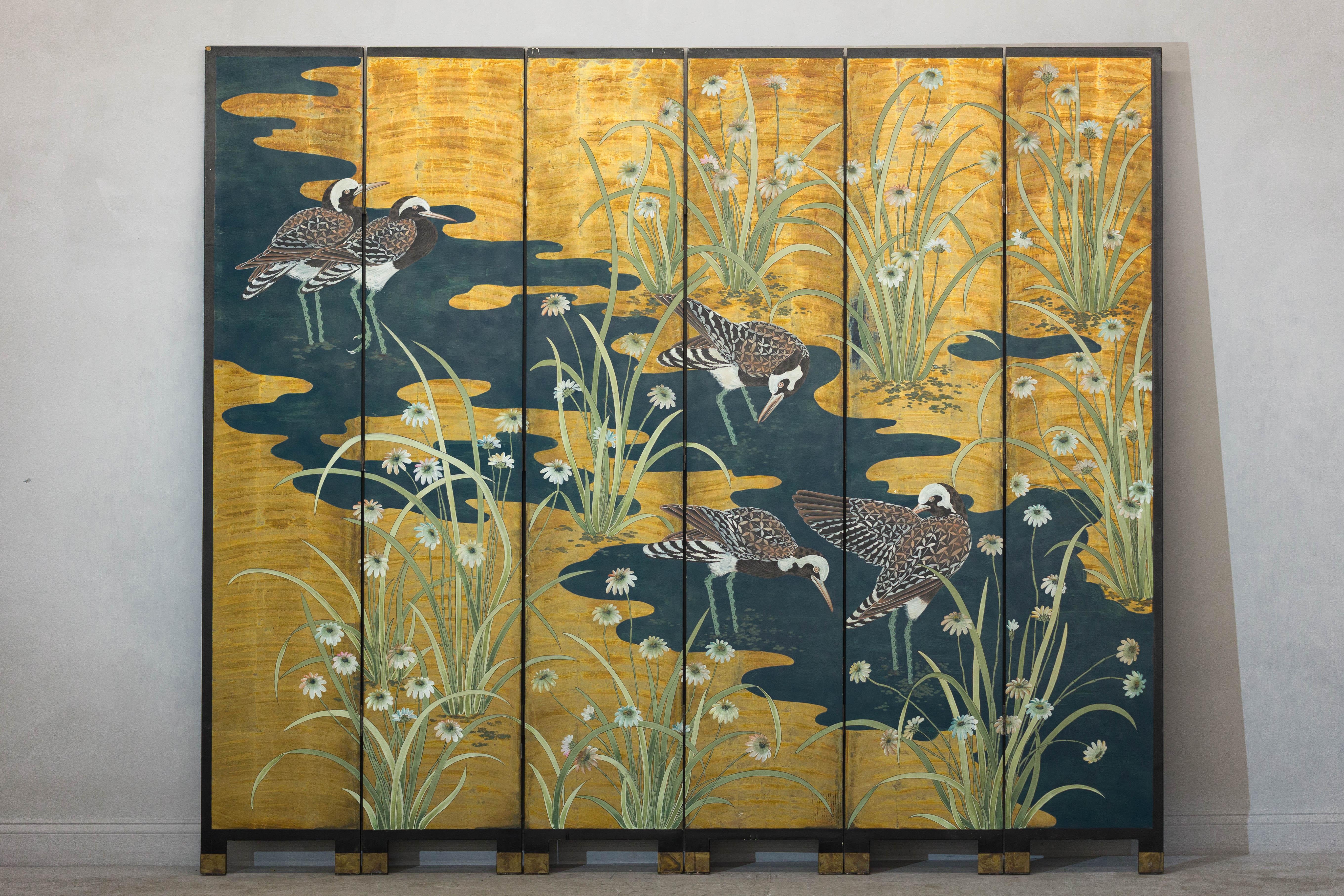 This exquisite vintage six-panel screen brings timeless elegance and artistry to your living space. Featuring an intricate hand-painted design, the piece showcases serene water birds amidst lush grasses and delicate blooms, all set against a richly