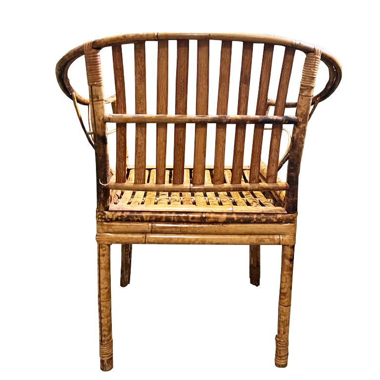 A gorgeous barrel-back bamboo armchair. This piece reminds us of a Brighton Pavillion chair. It has a rounded barrel back with a split bamboo back and seat. The arms feature pieces of bent bamboo on each side. This chair would be a great piece for a