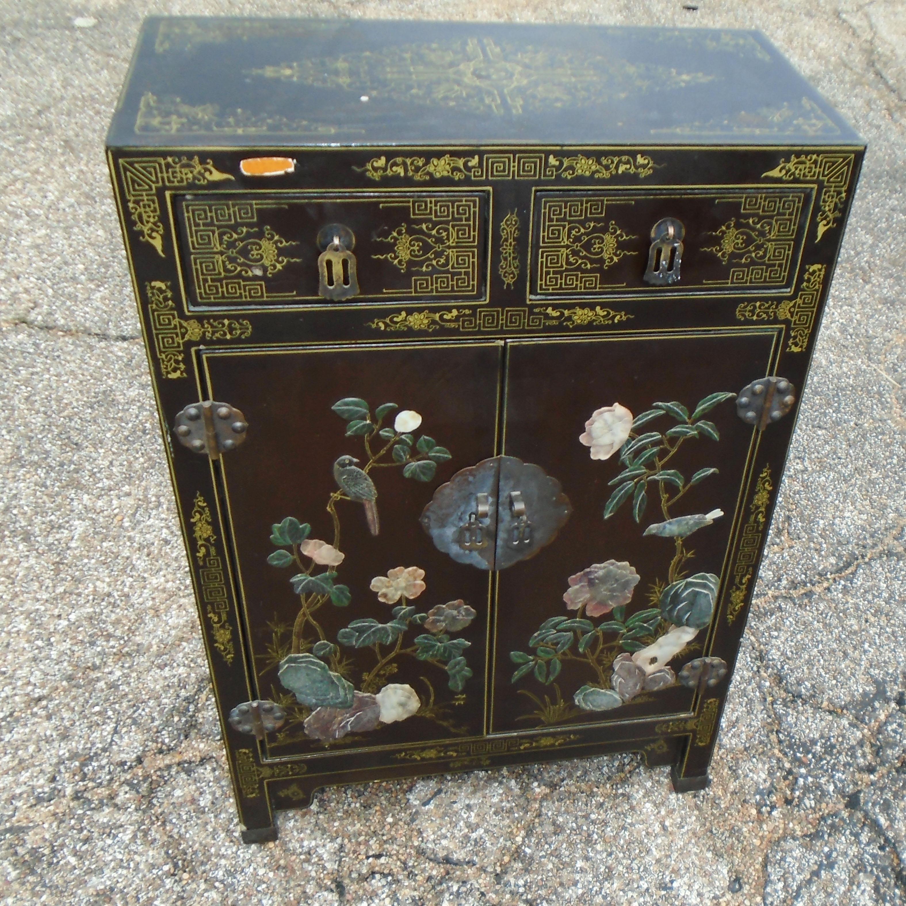 20th century lacquered wood small cabinet 
 
This beautifully detailed small piece is a perfect example of a chinoiserie cabinet from the early 20th century from China. The oriental bird and flower mother-of-pearl appliques are hand painted and