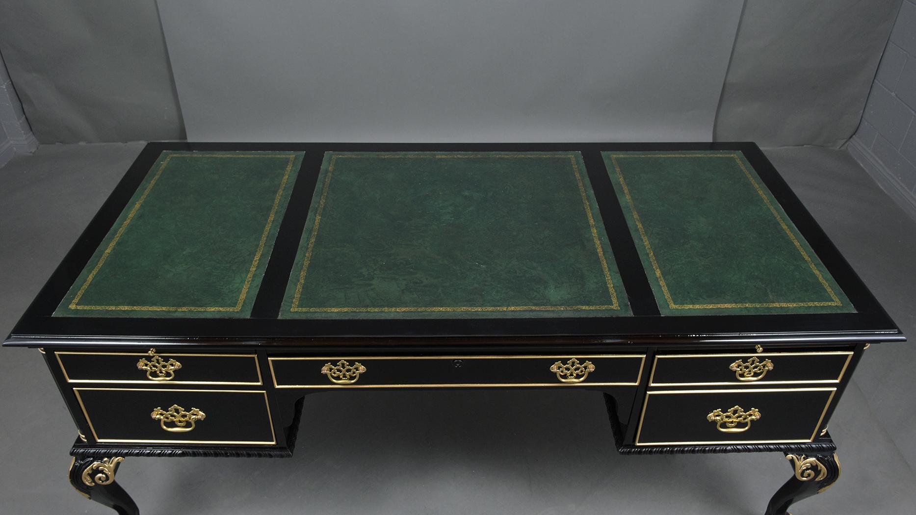 An extraordinary empire-style ebonized desk beautifully crafted out of mahogany wood that has been professionally restored by our team of craftsmen. This elegant executive desk features a new ebonized color stain with gilt-wood molding accents and