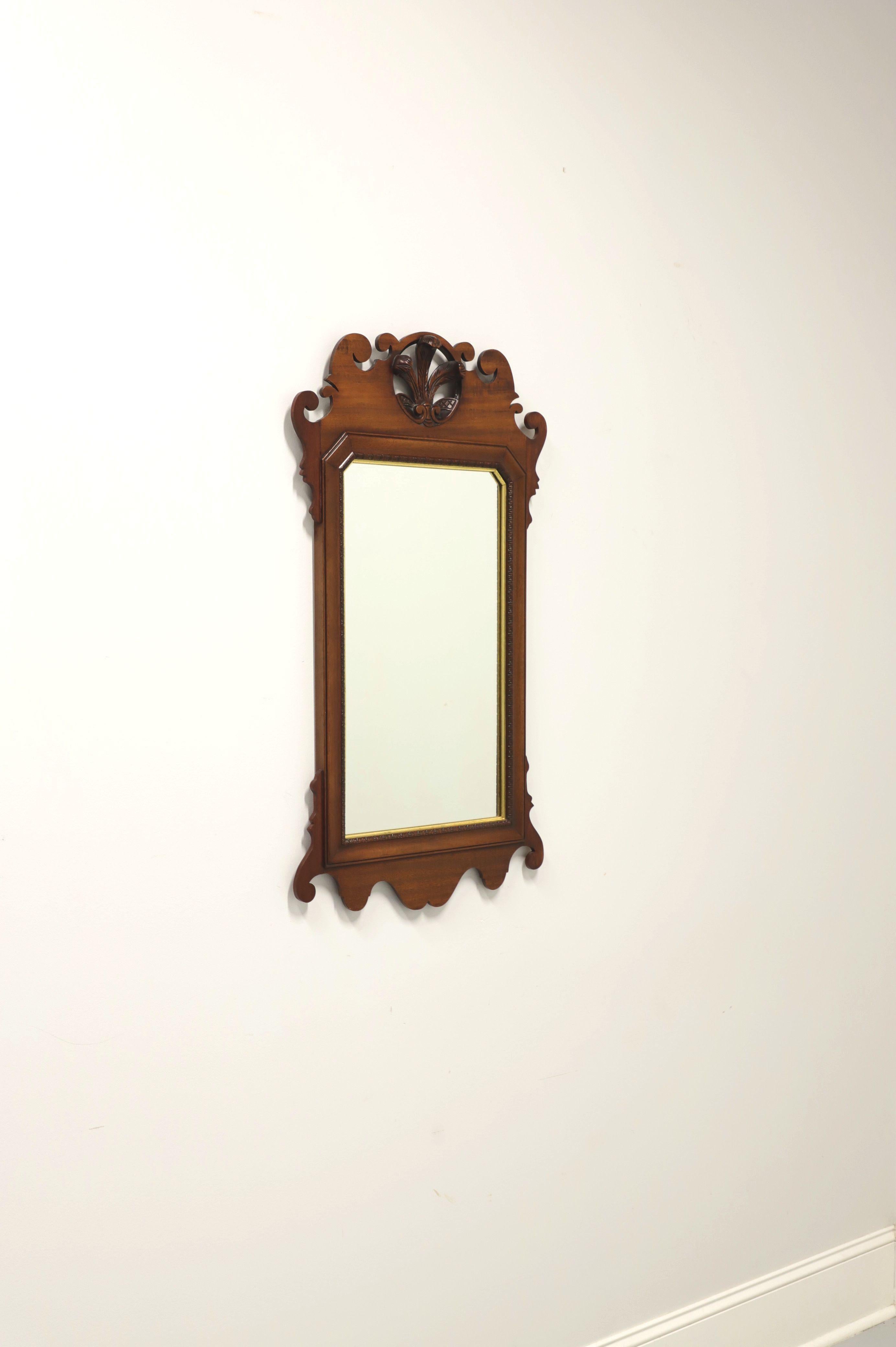 A Chippendale style wall mirror, unbranded, similar in quality to Henkel Harris or Henredon. Mirrored glass, mahogany frame with gold trim and top center Prince of Wales Plumes. Made in the USA, in the late 20th Century.

Measures: 20.5 W 1 D 36.75