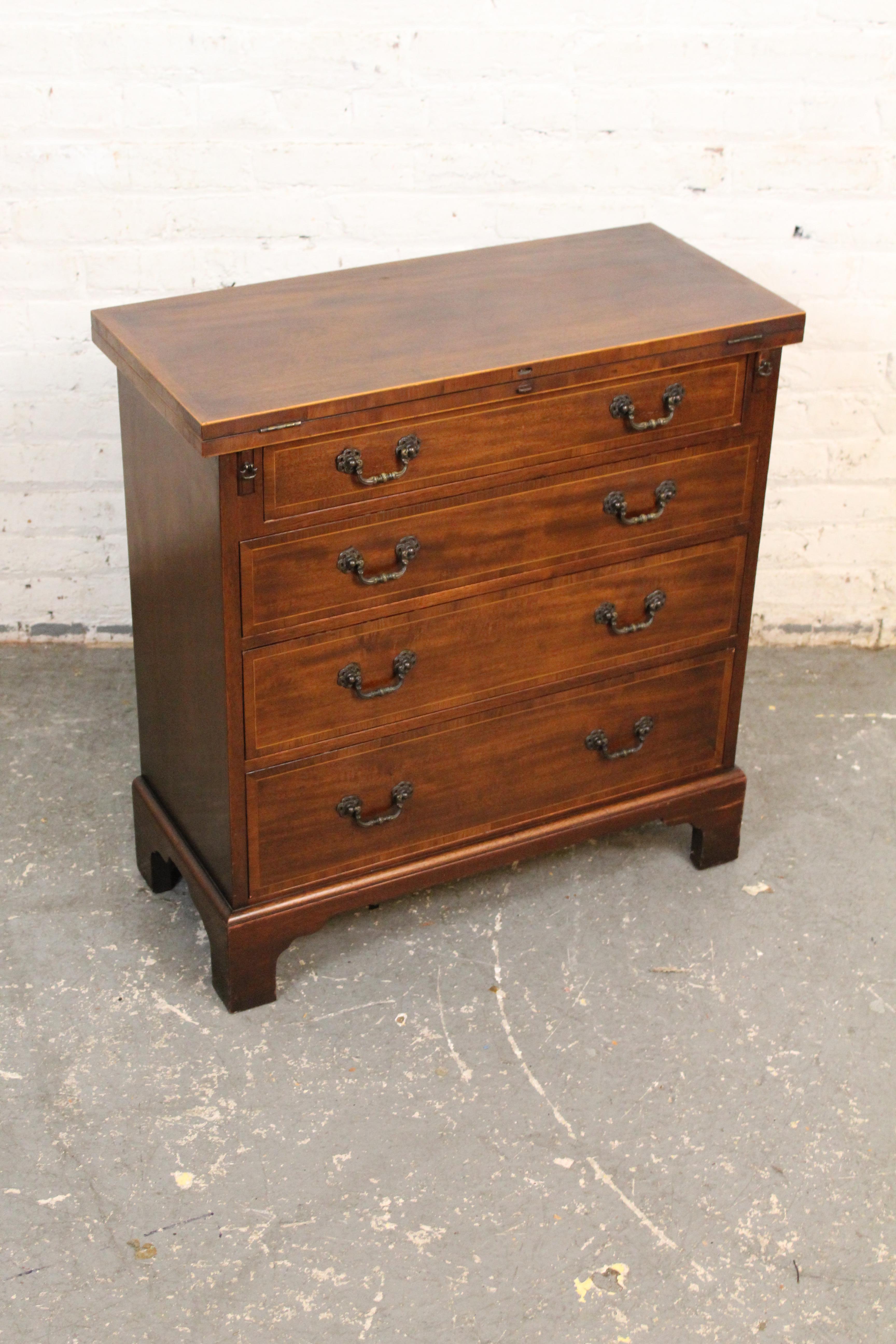 Embrace traditional English style and high-quality 20th-century American construction with this unique flip-top chest of drawers from the master craftsmen of North Carolina’s Baker Furniture. Featuring four dovetailed pull out-drawers boasting