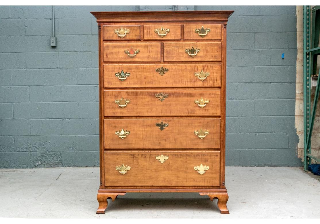 La cassettiera alta finemente costruita in finitura acero tigrato con piano a fasce e cornice a cavetto.  Il mobile ha tre cassetti corti su due cassetti corti su quattro cassetti lunghi graduati. Tutti con balle ad ala di pipistrello in ottone