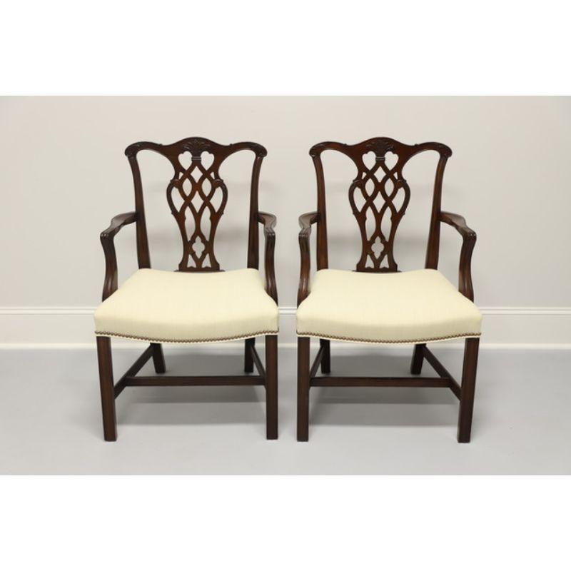 A pair of Chippendale style dining armchairs, unbranded, similar in quality to high-end furniture makers, such as Thomasville. Solid mahogany frame, fabric upholstery, carved backsplats; on a stretcher base with straight legs. Made in the USA in the