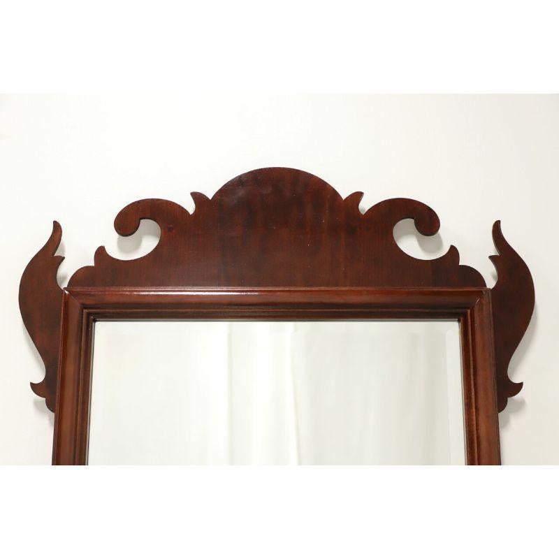 Ein Wandspiegel im Chippendale-Stil, ohne Markenzeichen. Verspiegeltes Glas in einem Mahagoni-Rahmen mit dekorativen Schnitzereien an der Ober- und Unterseite. Hergestellt in den USA, Ende des 20. Jahrhunderts.

Maße: 25 B 1,5 T 41,75 H, Wiegt ca.: