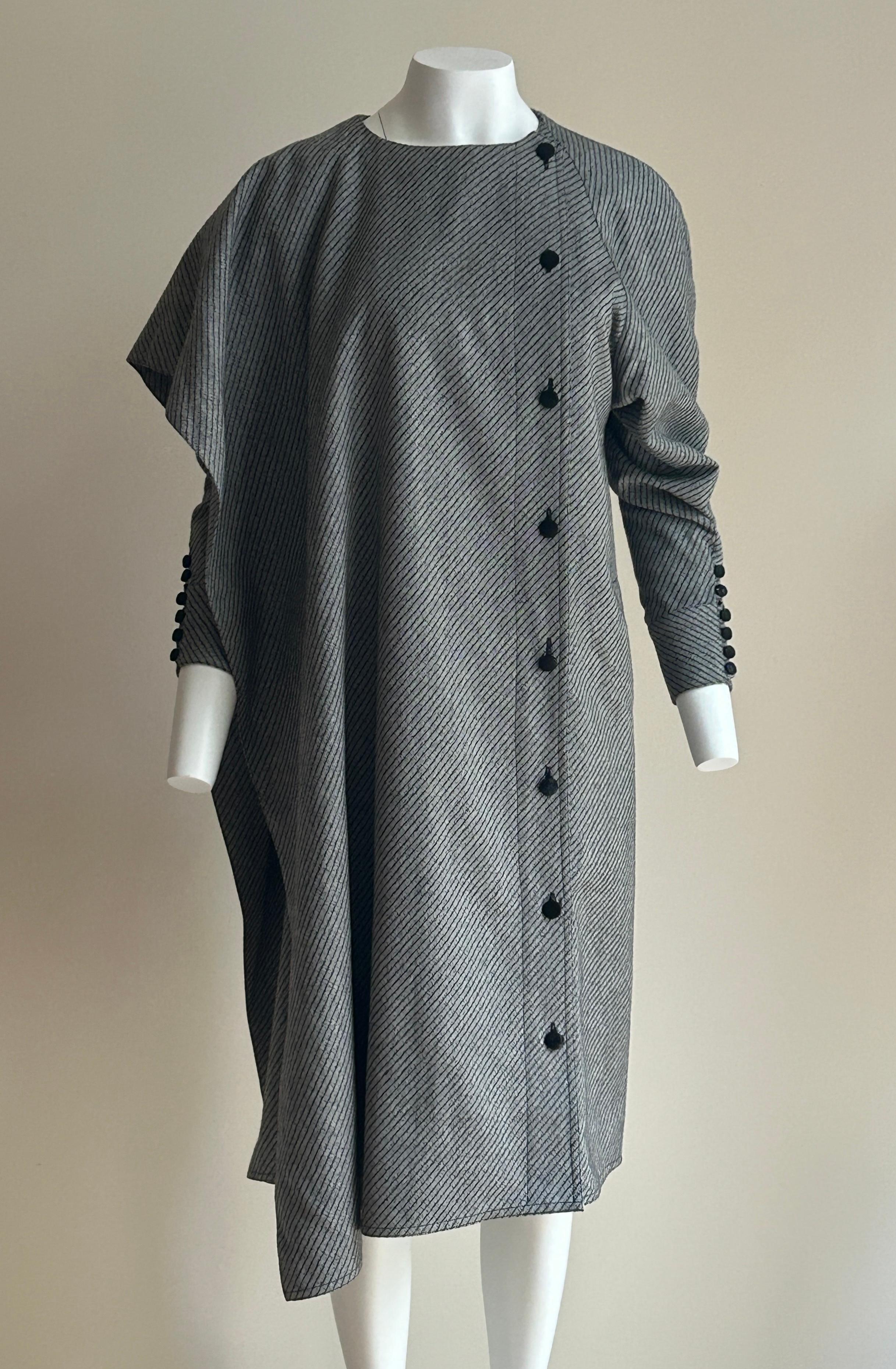 Abito asimmetrico in lana grigia vintage anni '80 Chloé per I. Magnin. Drappeggiato su un lato con maniche voluminose nella parte superiore e affusolate verso il polso. Sale e pepe classico  in una sottile striscia diagonale. Tasche sulle cuciture