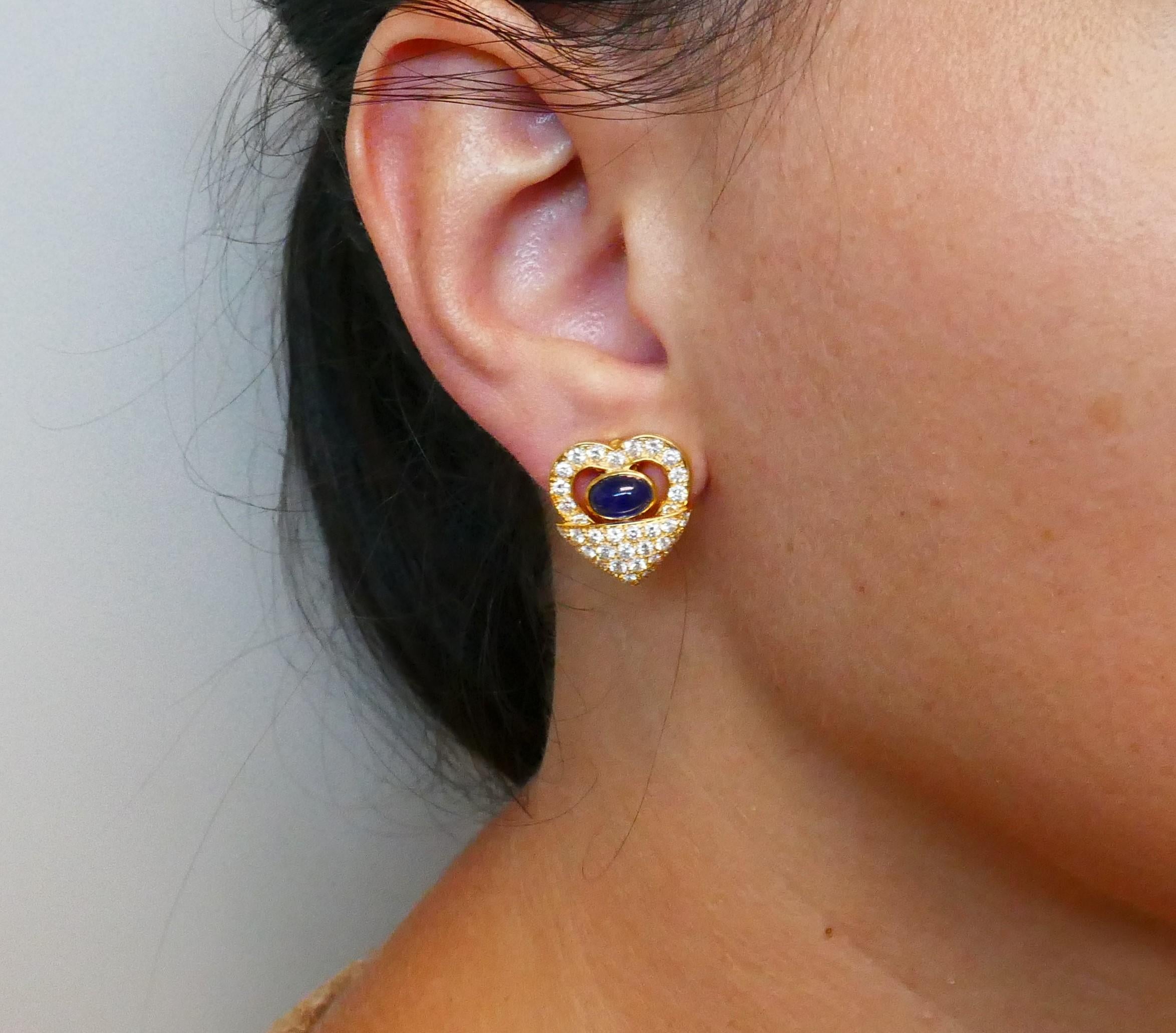 Elegant clip-on earrings made of 18 karat (stamped) yellow gold encrusted with round brilliant cut diamonds (F-G color, VS clarity, approximately 1.50 carats total weight) and featuring two cabochon sapphires (approximately 2 carats total