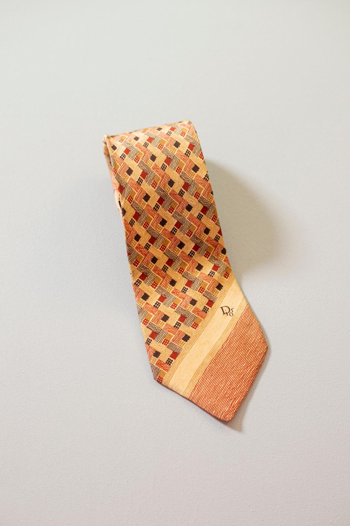 A timeless classic, this tie is designed by the famous designer Christian Dior, it is made of 100% silk. Decorated with geometric motifs in warm colors, in shades of beige. Thanks to its elegance, this accessory, if combined with a suit, can be