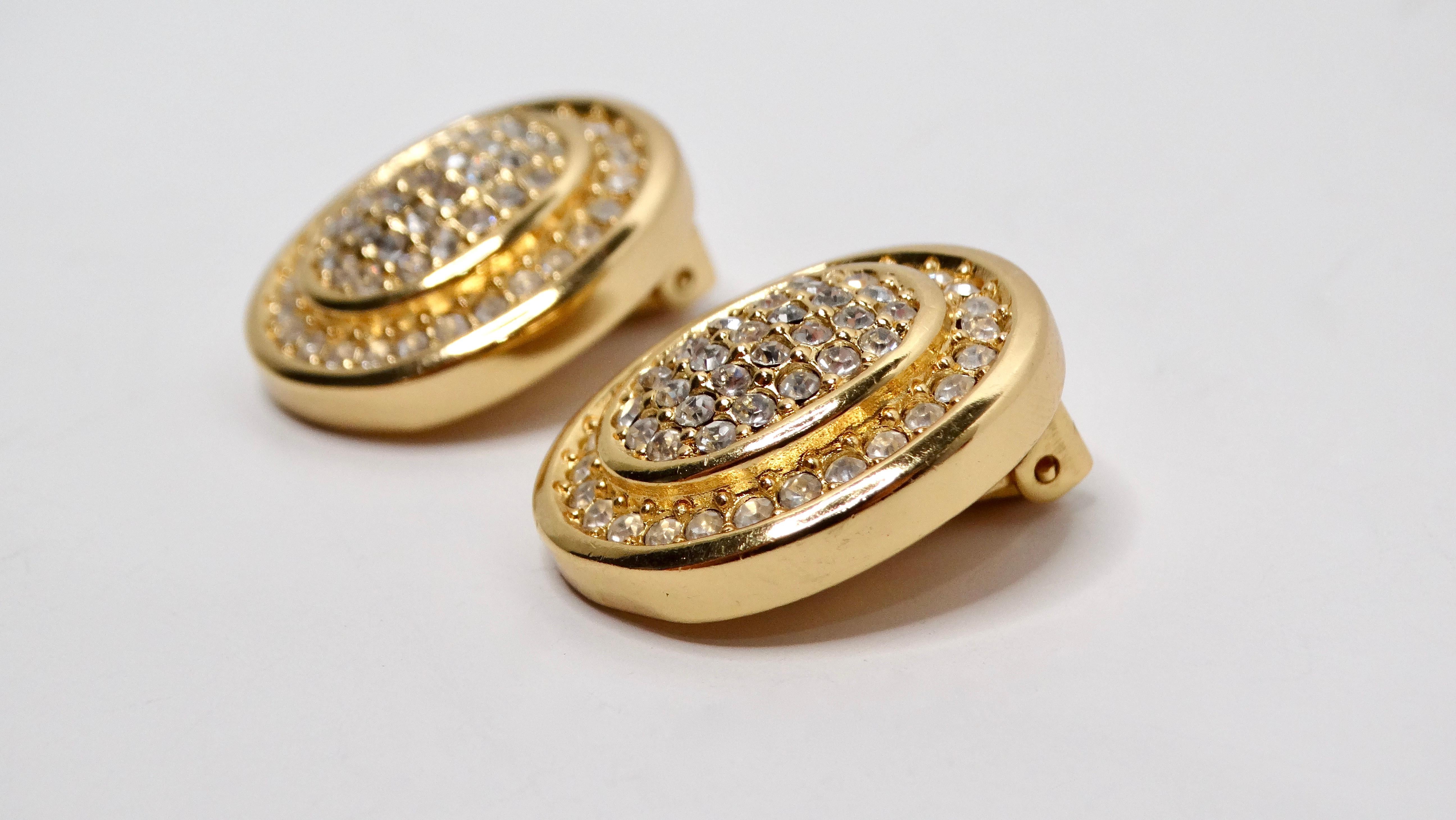 These Vintage Christian Dior 14k Gold Plated Rhinestone Clip-On Earrings are a stunning addition to any jewelry collection, showcasing a chunky oval shape embellished with sparkling rhinestones that exude timeless elegance. The gleaming gold plating