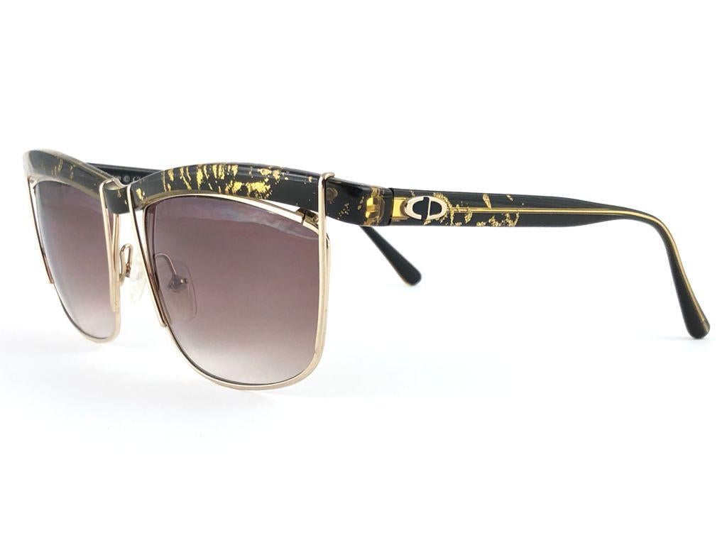 Vintage Christian Dior black with gold mosaic details sunglasses.

Spotless medium brown lenses.

This item may show light sign of wear on the frame due to storage.

MESUREMENTS:

FRONT : 14 CMS
LENS HEIGHT : 4 CMS
LENS WIDTH : 5.4 CMS
TEMPLES :