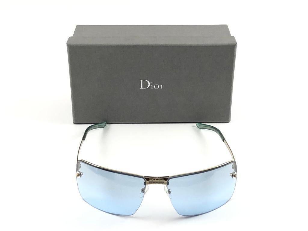 Vintage Christian Dior Adiorable lunettes de soleil argentées avec des lentilles bleu clair Wrap Fall 2000 par Galliano.

Fabriqué en Autriche.
 
Cette pièce présente des signes mineurs d'usure dus à  stockage.

Avant : 14.5 cms

Hauteur de