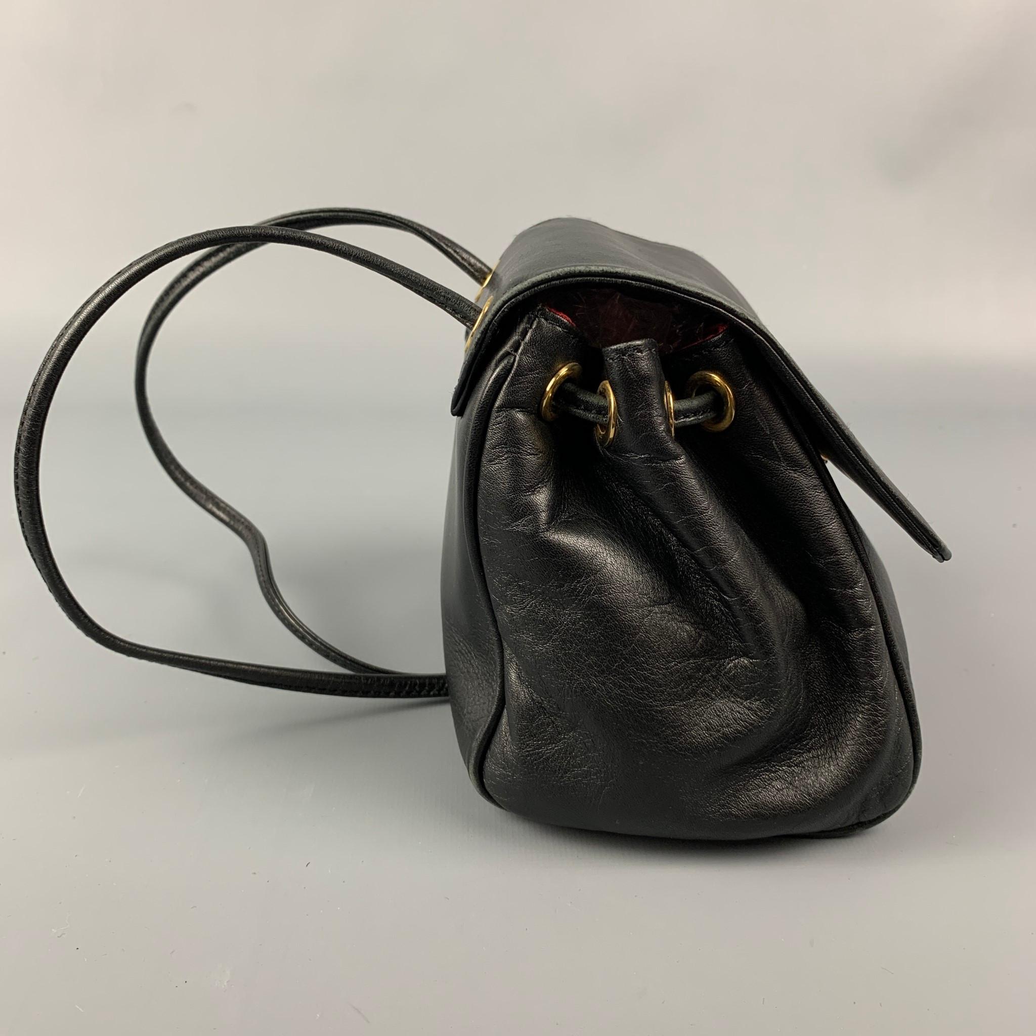 Vintage CHRISTIAN DIOR handbag comes in a black leather featuring gold tone logo charm details, red monogram print interior, mini, adjustable straps, and a snap button closure. Made in Italy.

Very Good Pre-Owned Condition.

Measurements:

Length: