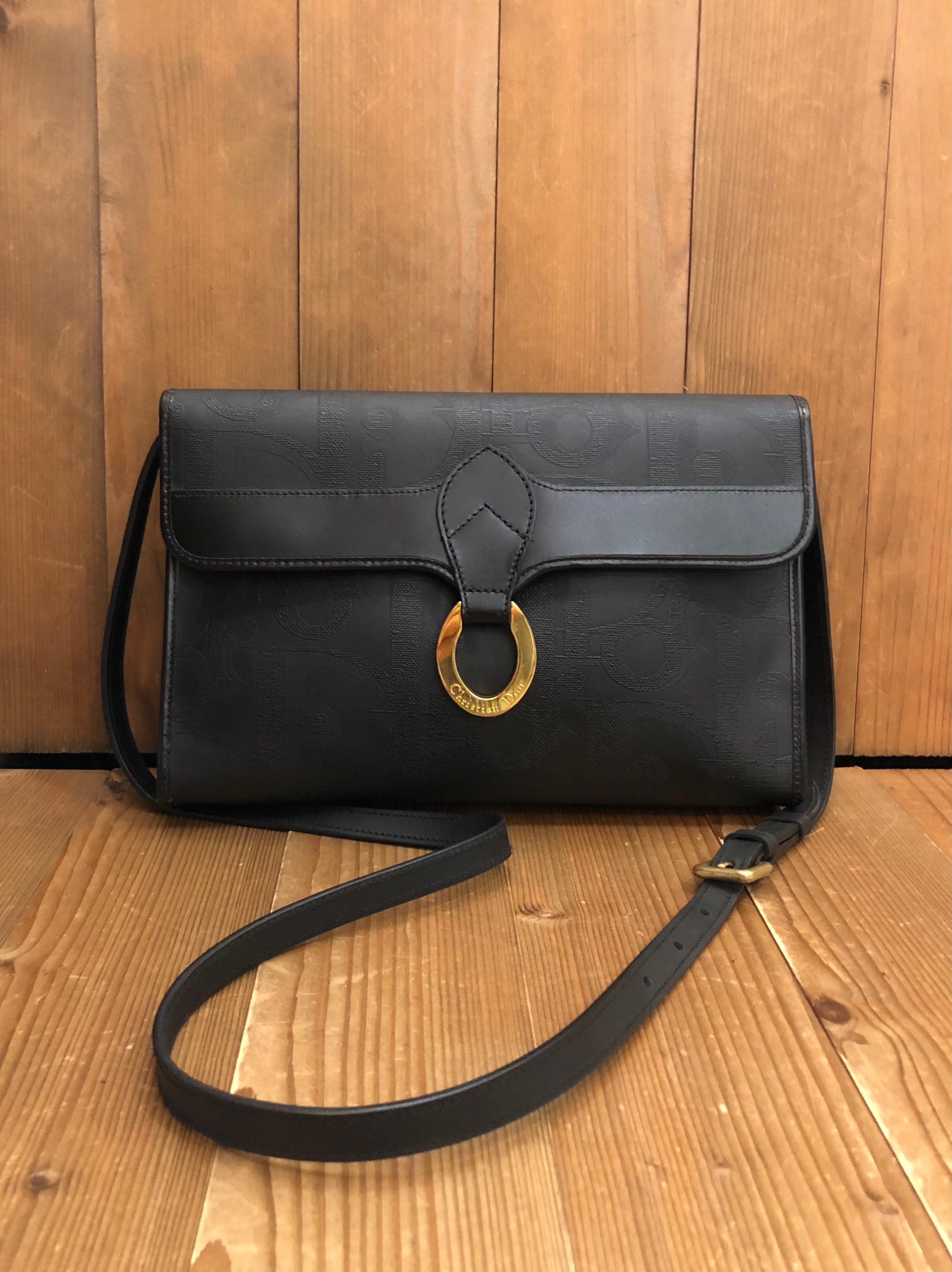 Vintage CHRISTIAN DIOR 2-way clutch/crossbody bag in Dior’s black coated canvas featuring a front flap magnetic snap closure. This Dior opens to a beige coated interior with a zippered pocket in the middle. It can be carried as a clutch without the