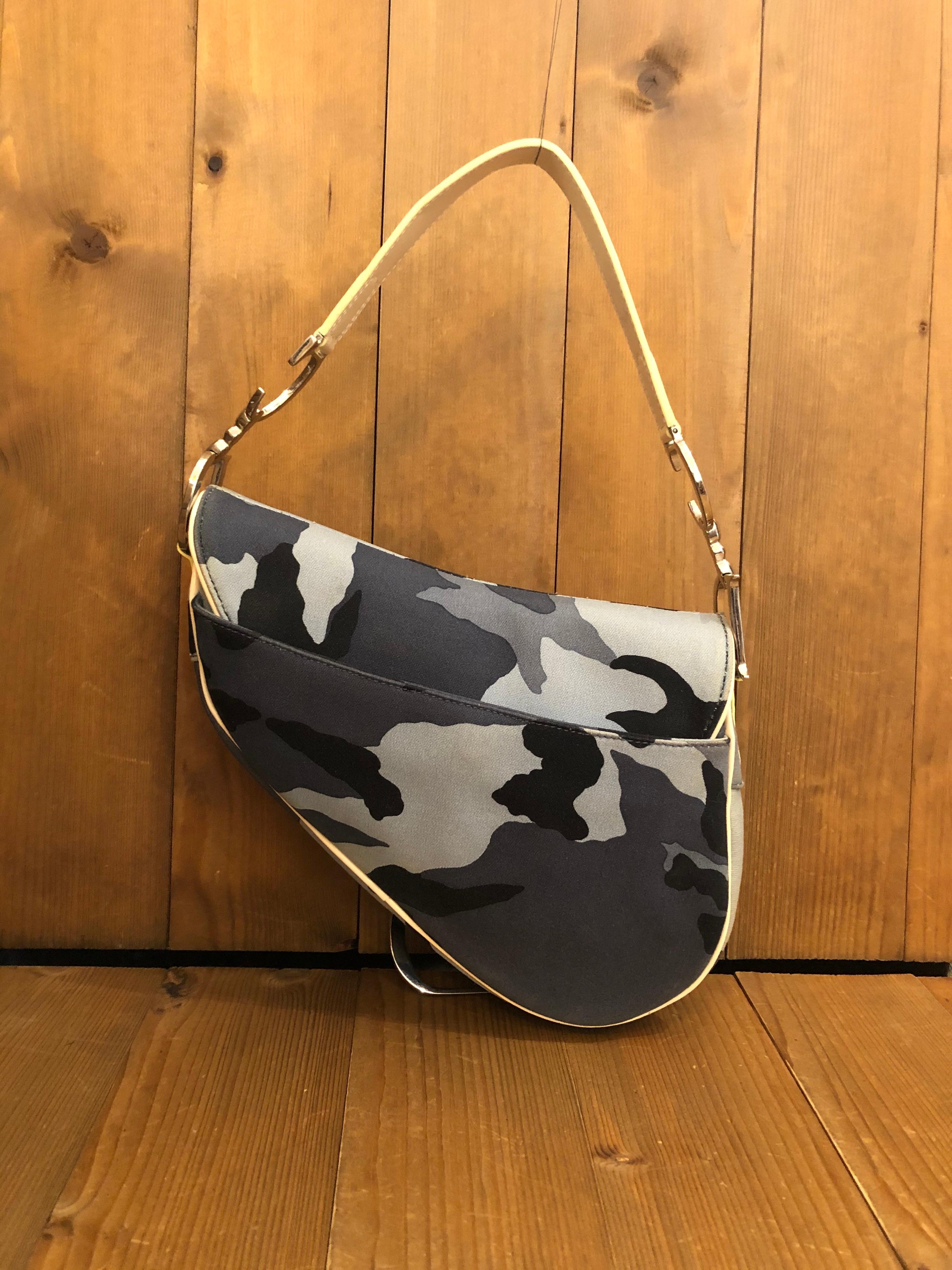 An iconic vintage Christian Dior Saddle Bag in Blue Camouflage Canvas and patent leather shoulder strap in ivory from the early 2000s under the influence of John Galliano. Made in Italy. Measures 24 x 20.25 x 5 cm Drop 17.75 cm (9.5 x 8 x 2 inches