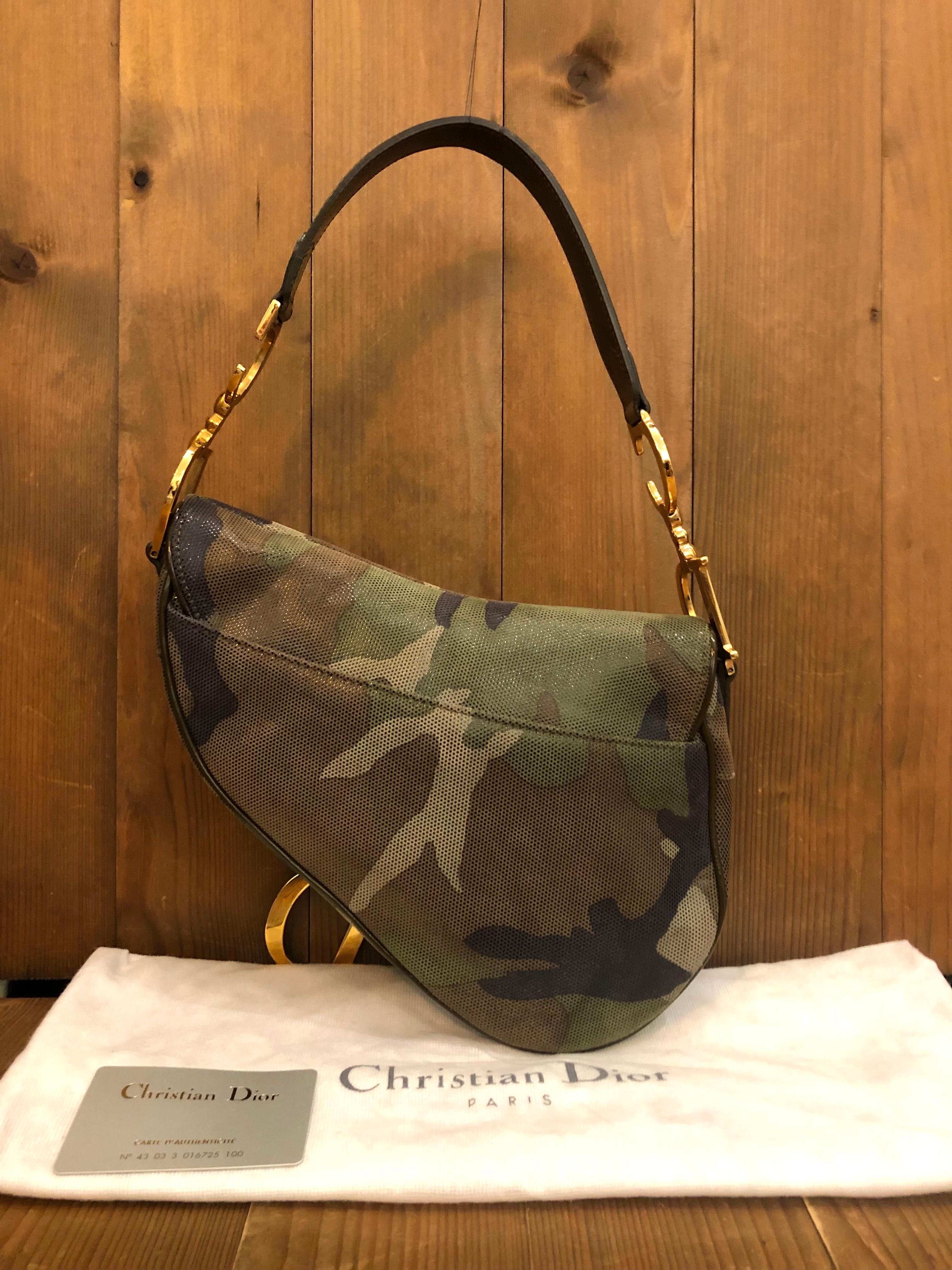 An iconic vintage Christian Dior Saddle Bag in green camouflage coated canvas from the year 2000 under the influence of John Galliano. This Dior saddle was purchased at the Dior Store at Landmark Mall in Hong Kong. Made in Italy. Measures 24 x 20.25