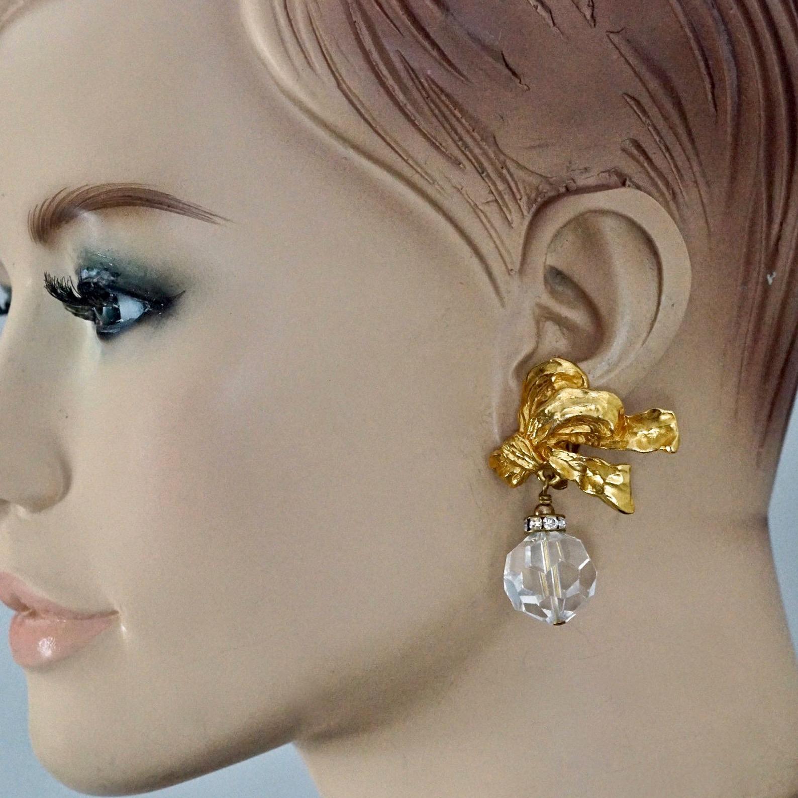Vintage CHRISTIAN DIOR BOUTIQUE French Bow Faceted Bead Earrings

Measurements:
Height: 1.96 inches (5 cm)
Width: 1.45 inches (3.7 cm)
Weight per Earring: 20 grams

Features:
- 100% Authentic CHRISTIAN DIOR BOUTIQUE.
- French bow with dangling